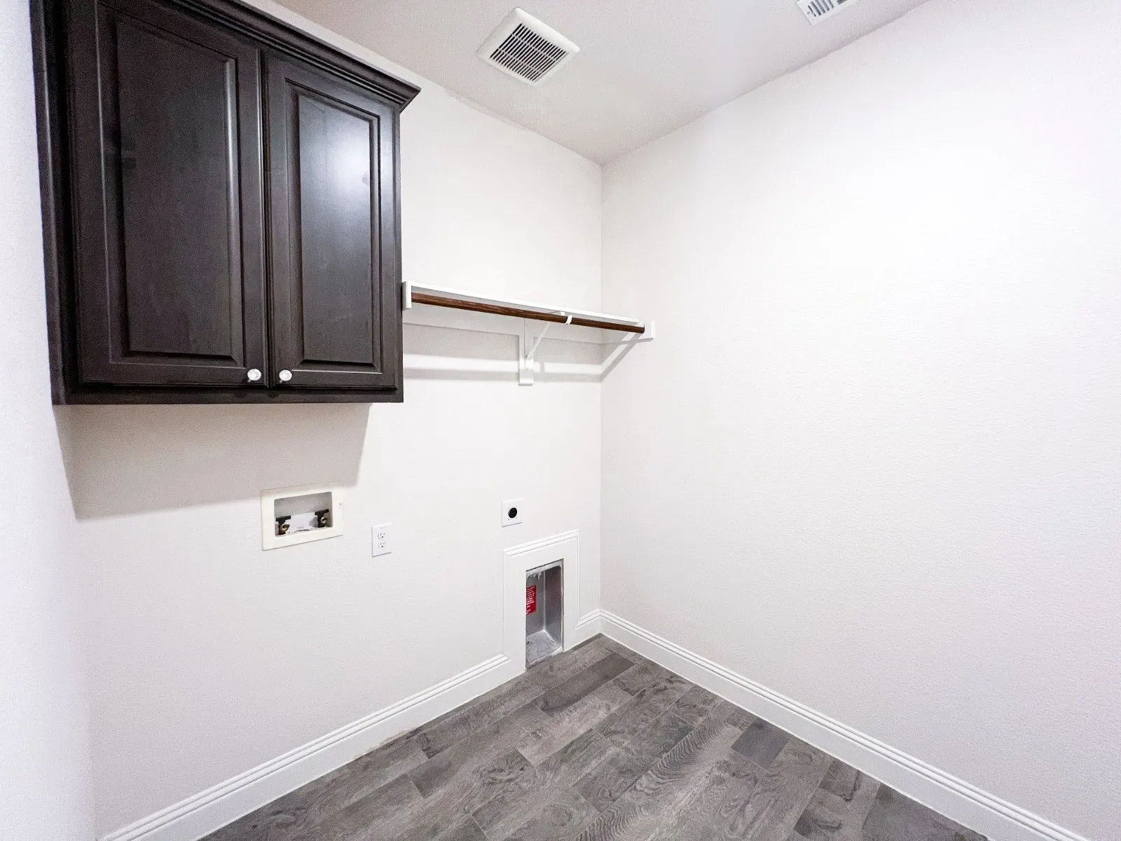 Dark wood-finish cabinetry, built-in shelving, and wood-finish flooring