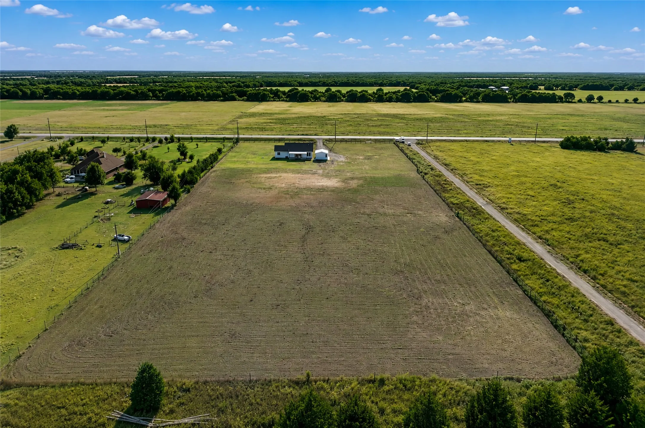 Expansive rural property featuring a primary residence and additional structures