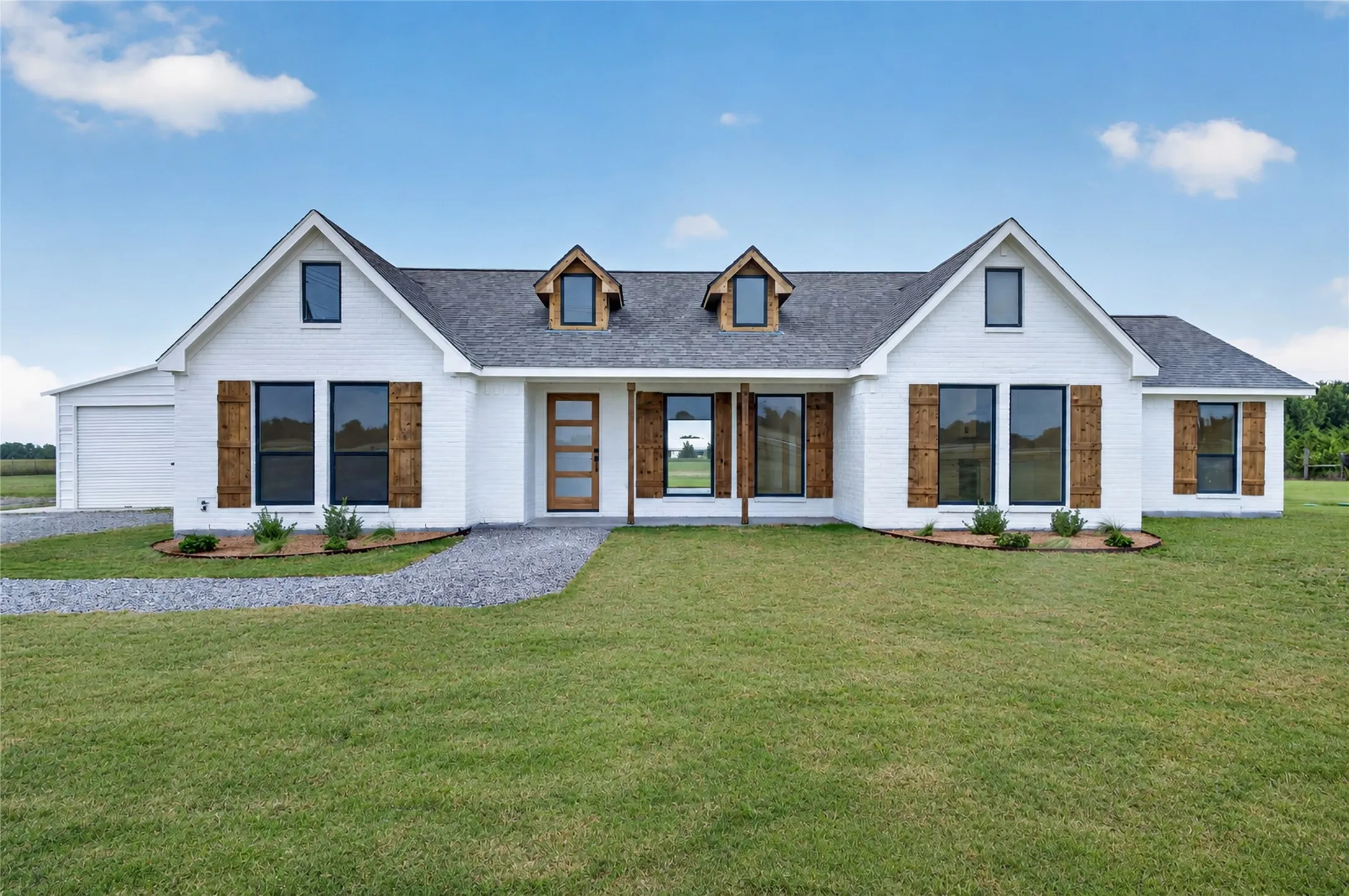 White brick exterior with dark-framed windows and wood-finish shutters