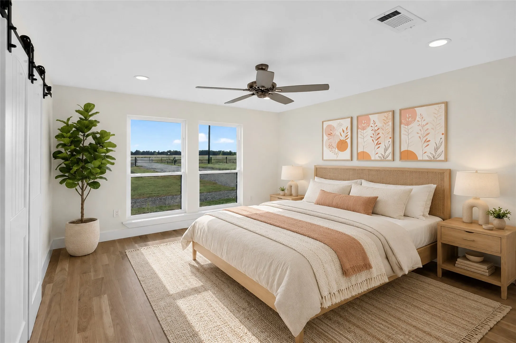Dual windows overlooking a field, wood-finish flooring, a ceiling fan with integrated lighting, recessed lighting, and a white barn door - Virtually Staged