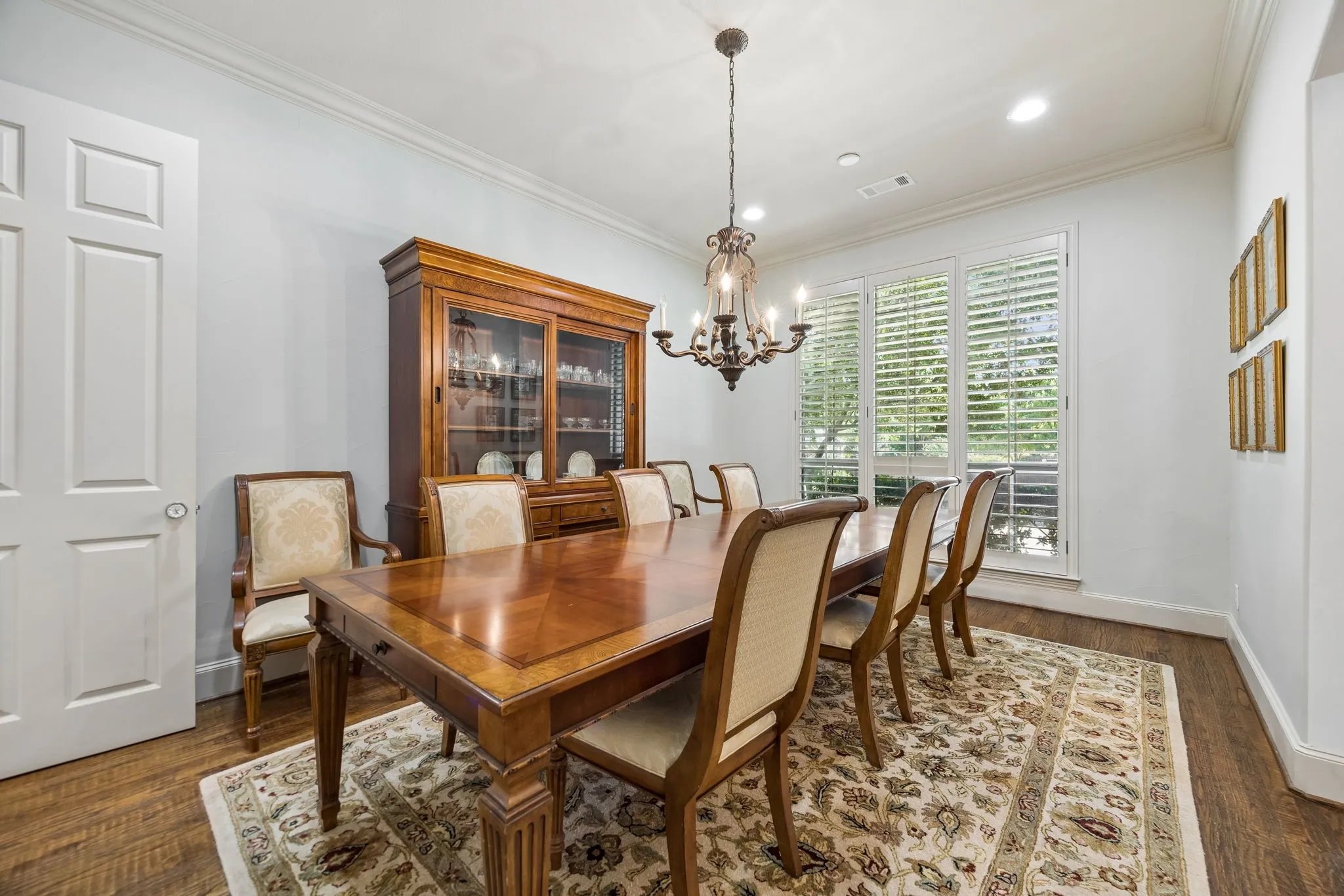 Spacious formal dining room with crown molding and hand-scraped wood flooring