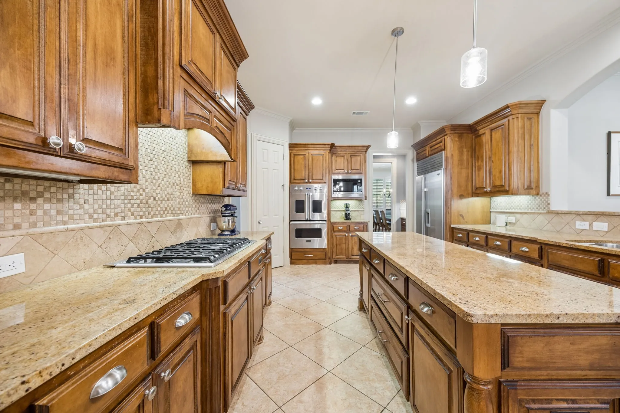 Extensive wood cabinetry, granite countertops, Viking 6 burner gas range, dual wall ovens, and a central island