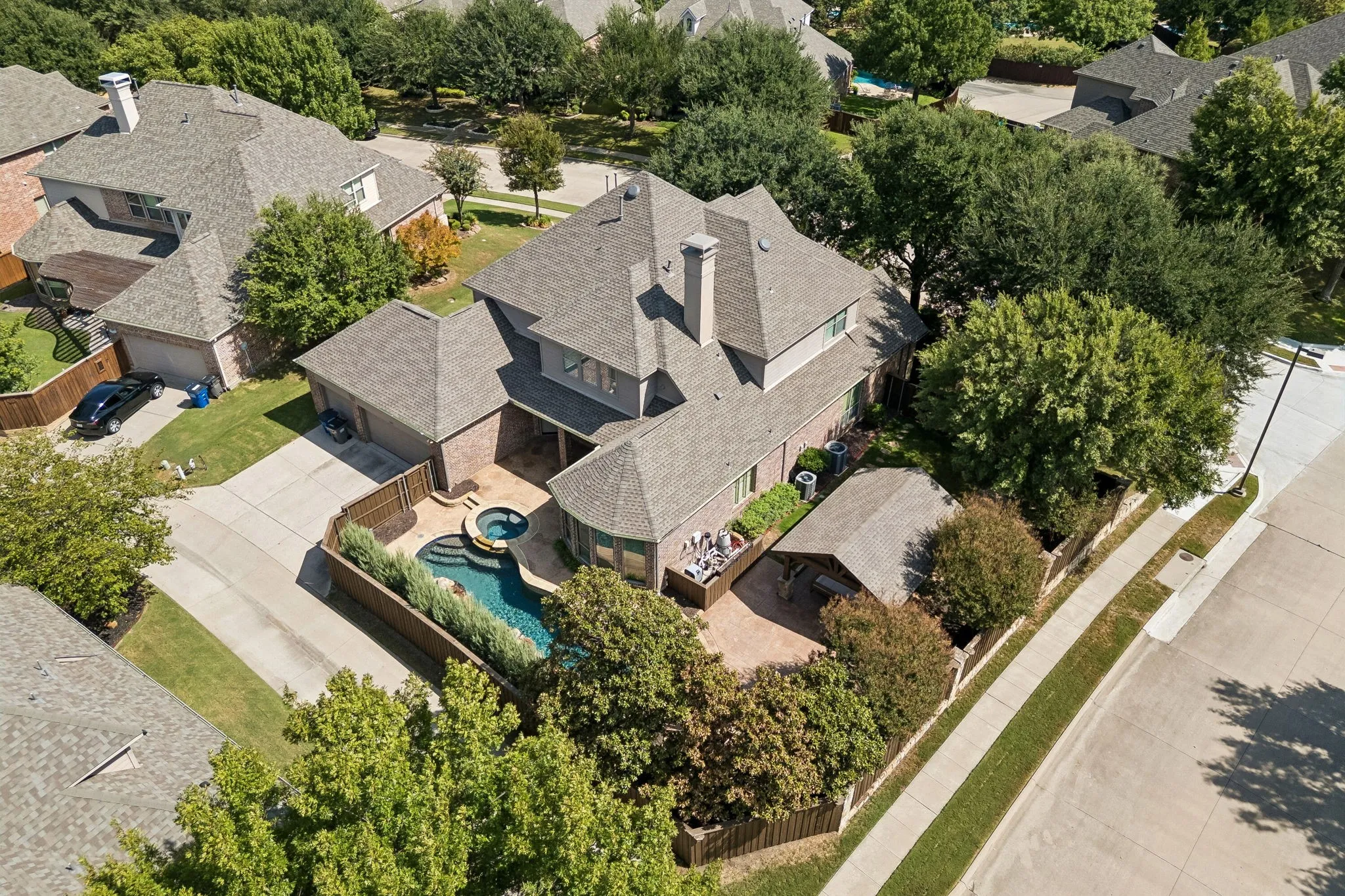 Two-story residence featuring a private swimming pool with integrated spa, an attached garage, and an additional covered outdoor patio area