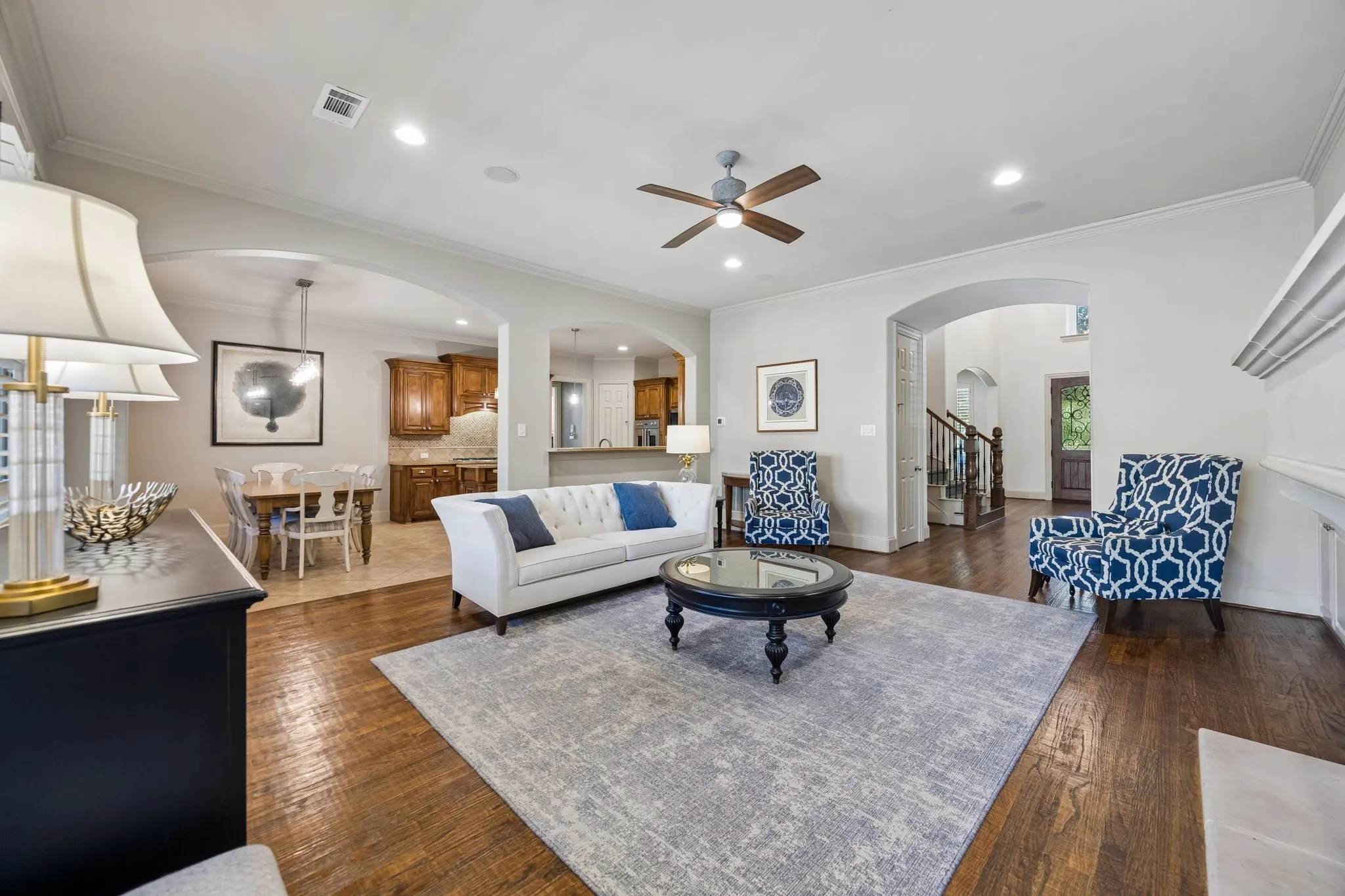 Hardwood flooring, recessed lighting, crown molding, arched doorways, and a ceiling fan