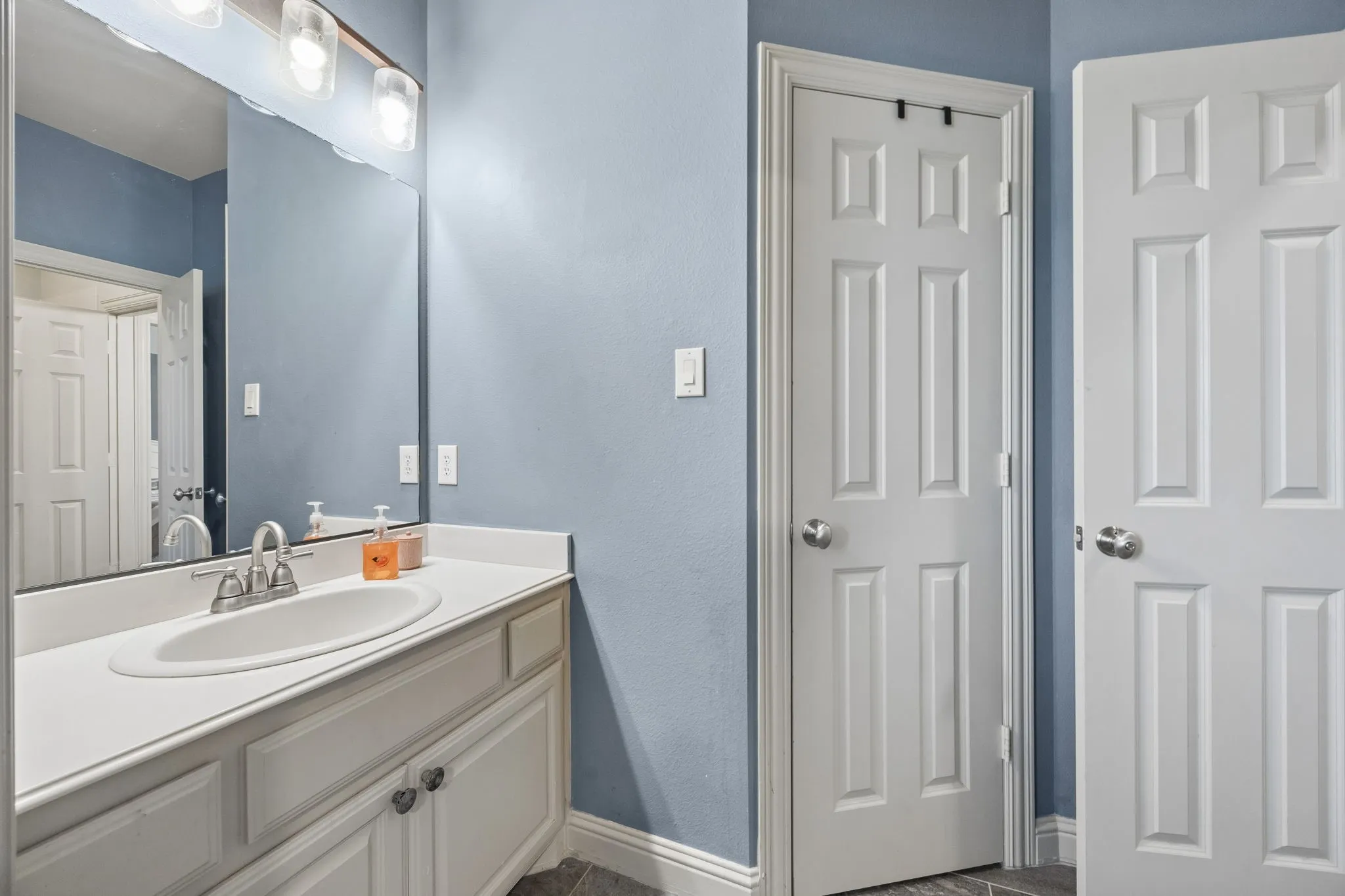 Vanity serves on of the bedrooms and has a walk in closet