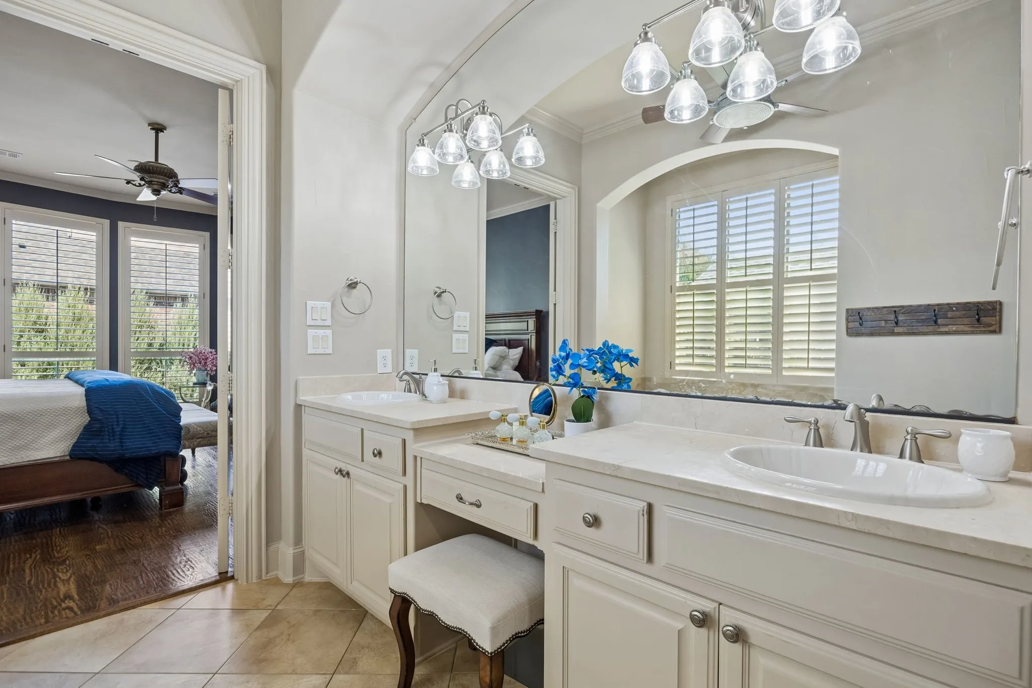 Dual vanity with integrated sinks, light-toned countertops, and cream-colored cabinetry