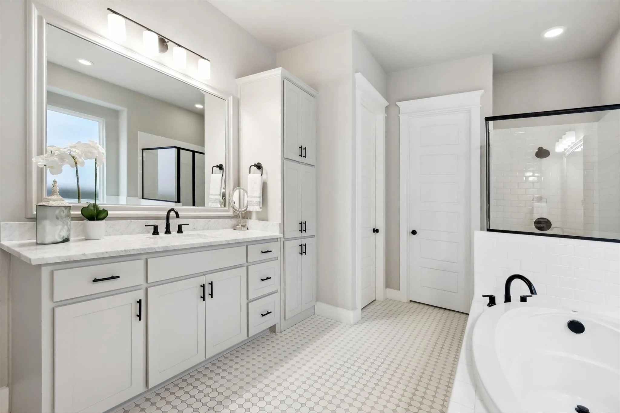 Dual vanity with white cabinetry, matte black fixtures, built-in storage, and a white countertop