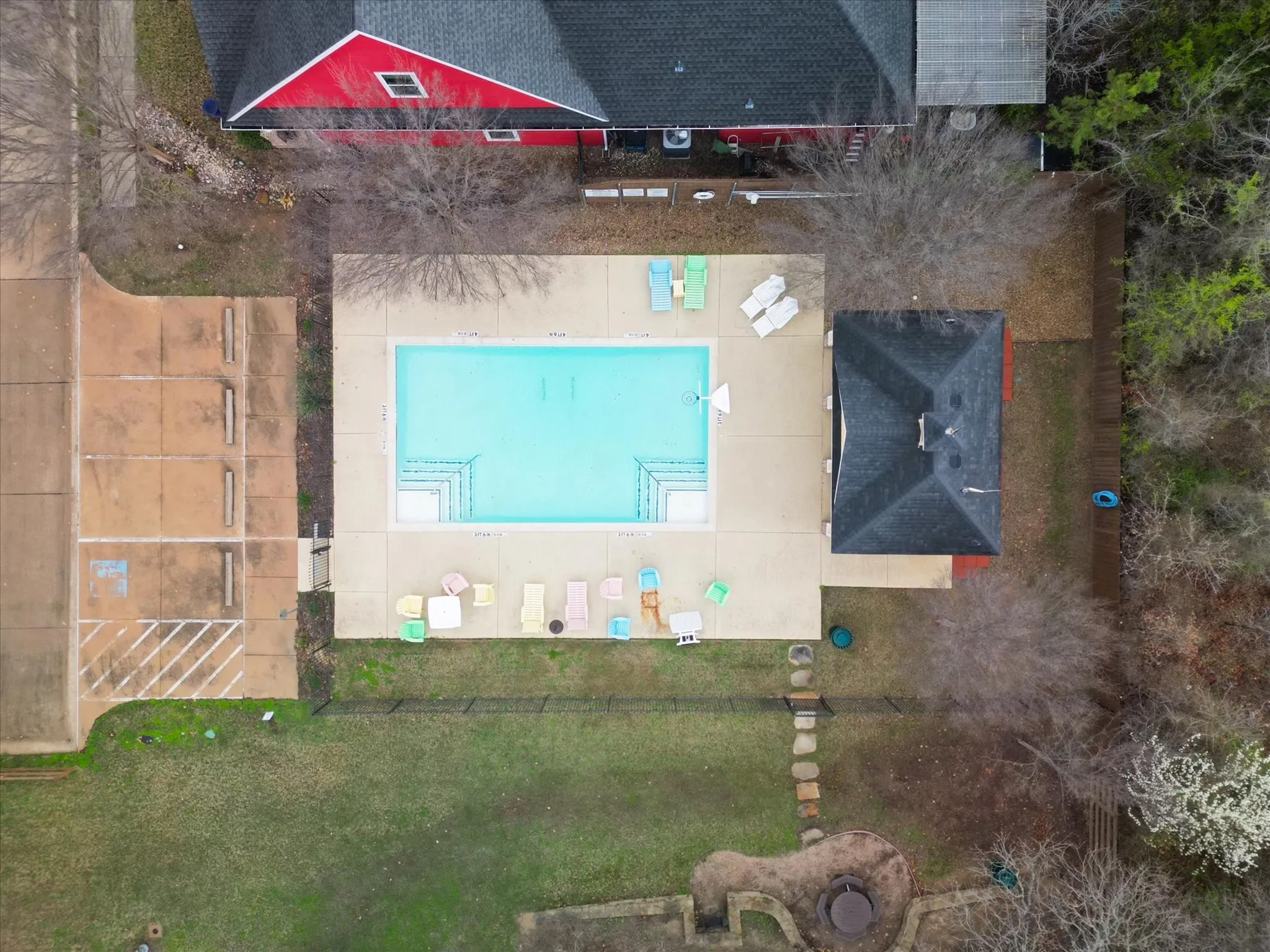 Rectangular swimming pool with integrated steps, surrounded by a concrete patio