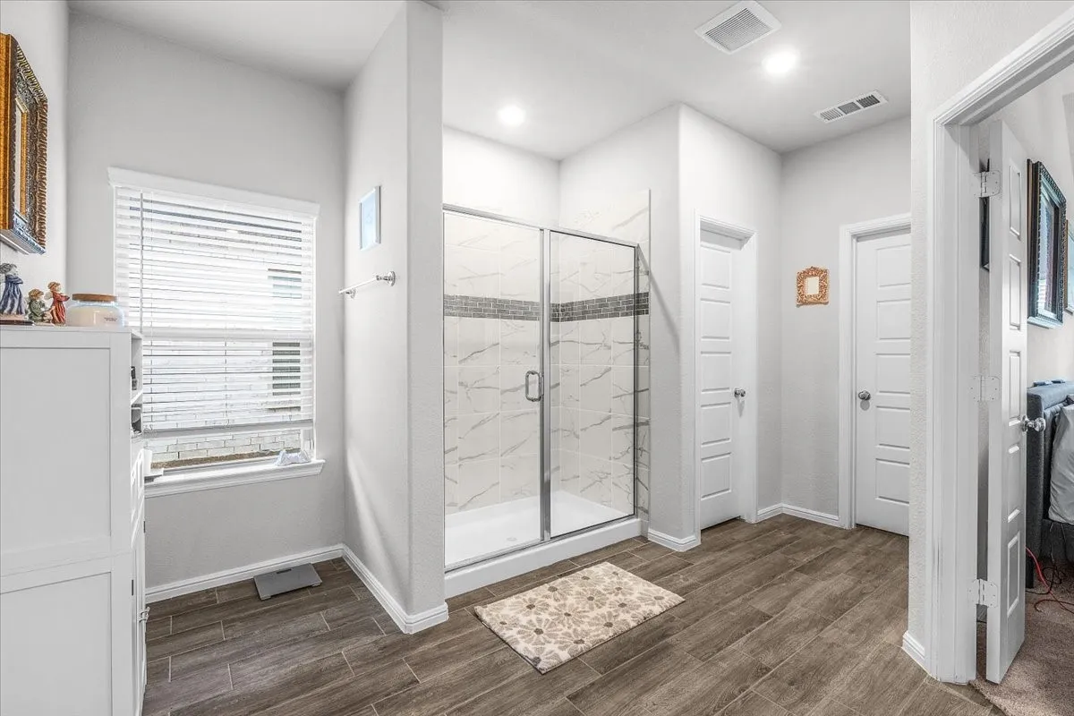 Enclosed shower with clear glass door and tiled surround