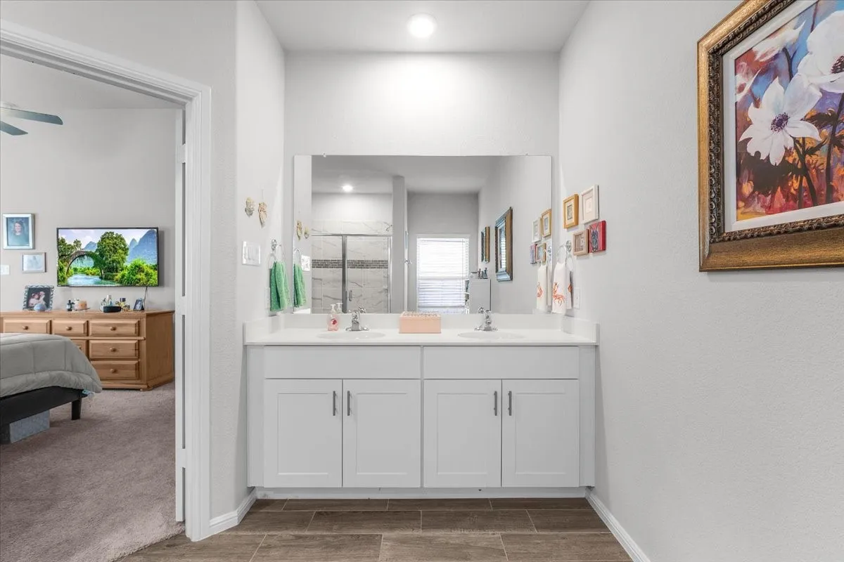 Double vanity with white cabinetry, under-mount sinks, and a large mirror