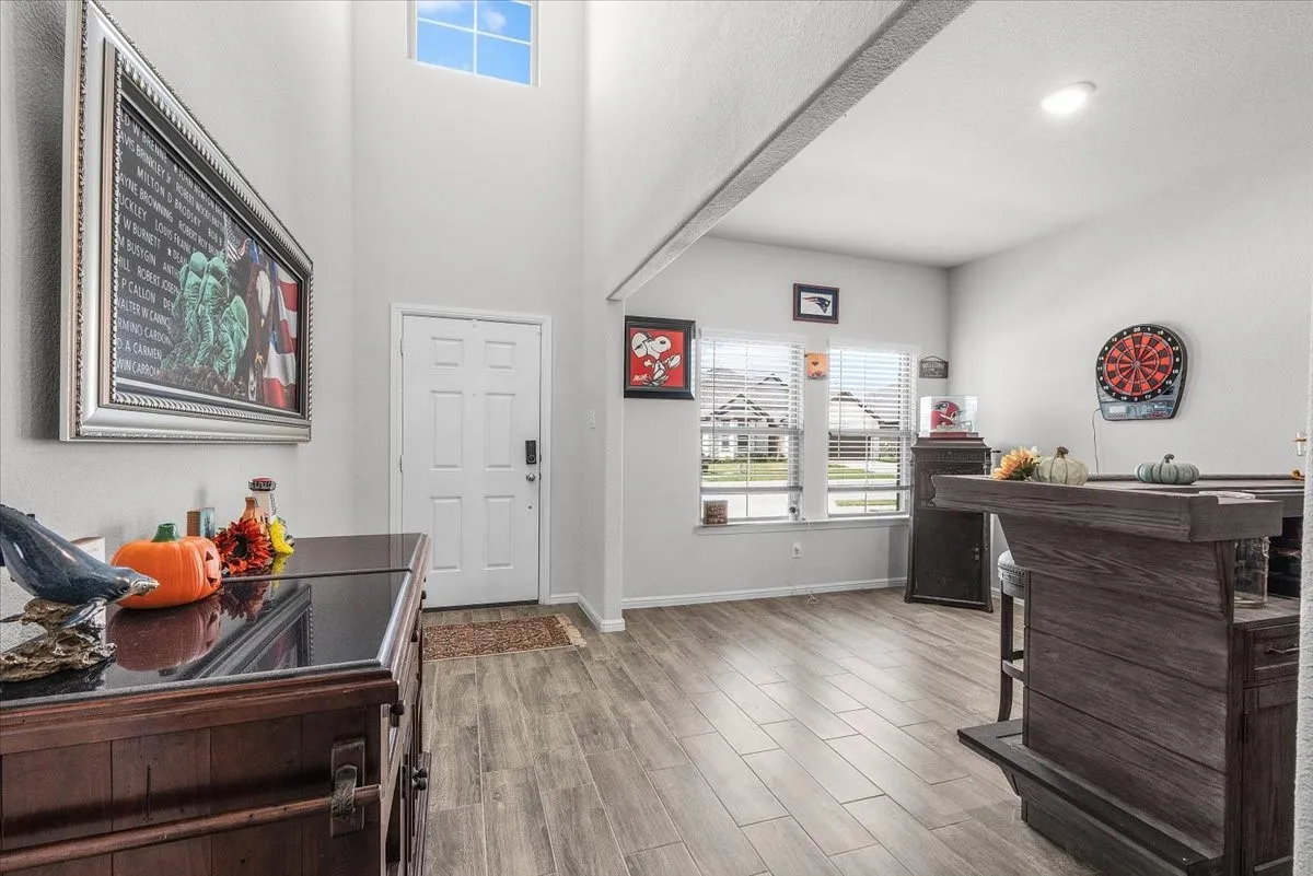 Foyer with double-height ceiling, transom window, wood-finish flooring, and a panel door entry