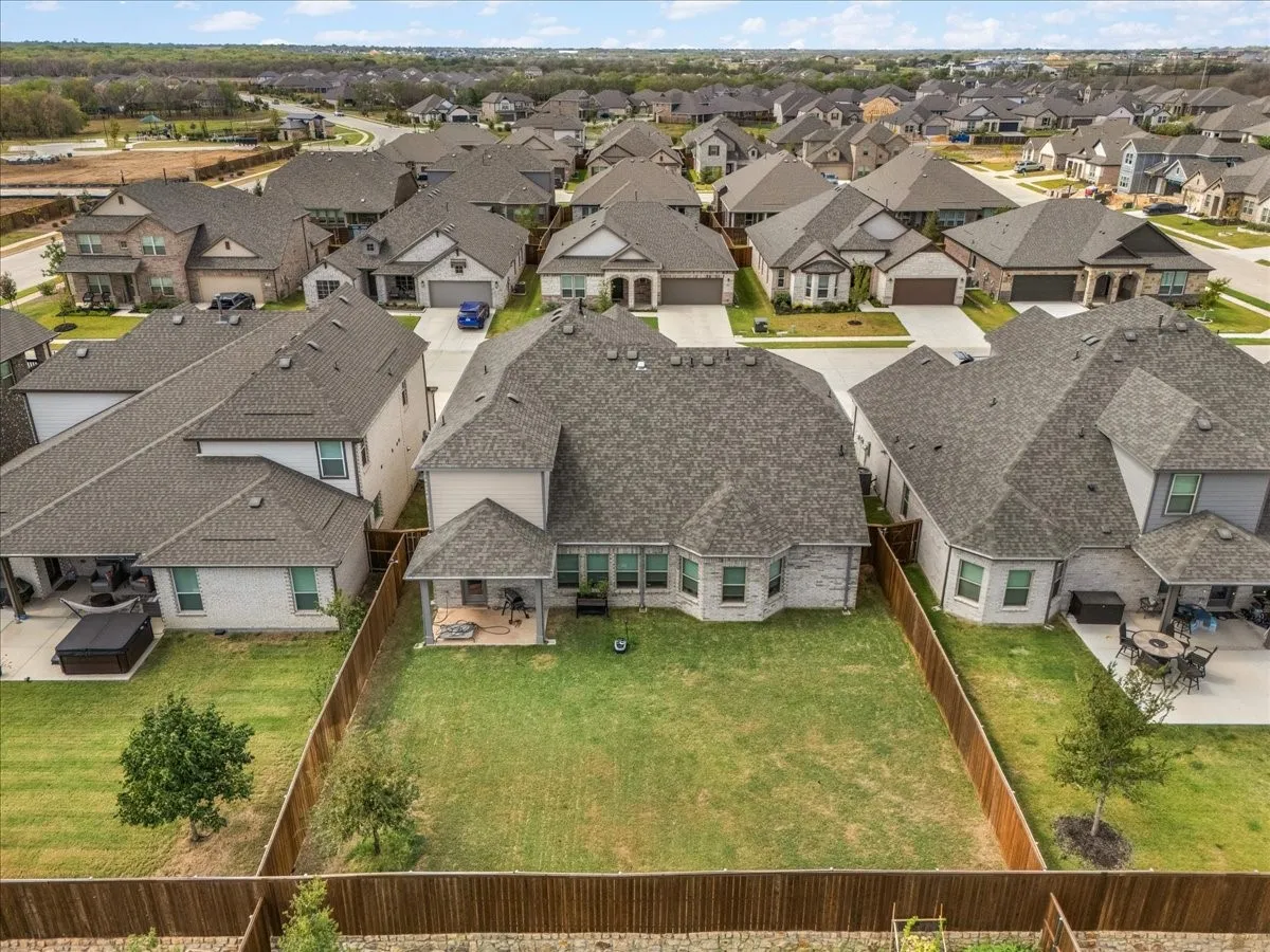 Expansive backyard featuring a covered patio, established lawn, and privacy fencing