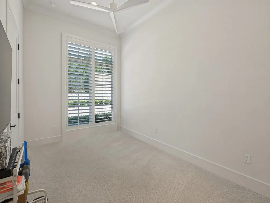 The second bedroom is currently used as a home gym, but also makes a perfect quest bedroom featuring plantation shutters, a walk in closet, ceiling fan, and ensuite bathroom.