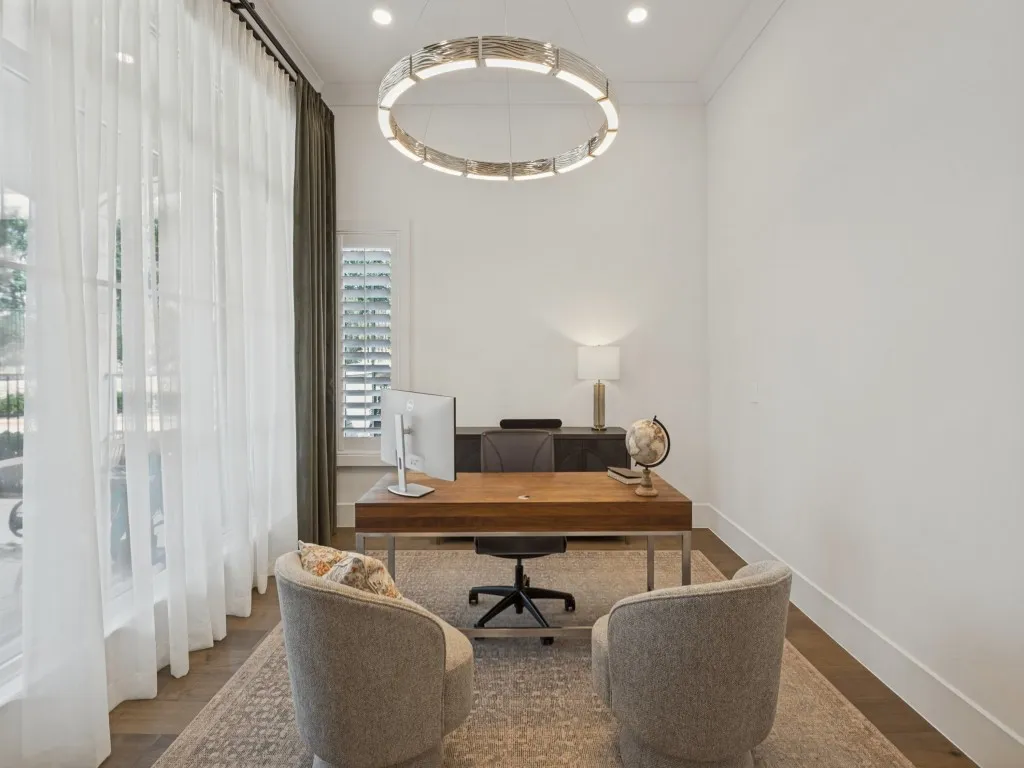 Beautiful work or study area is also adjacent to the living room. There are large windows overlooking the patio, and plantation shutters on the back side of the room for privacy. The wonderful chandelier is the accent of the room!