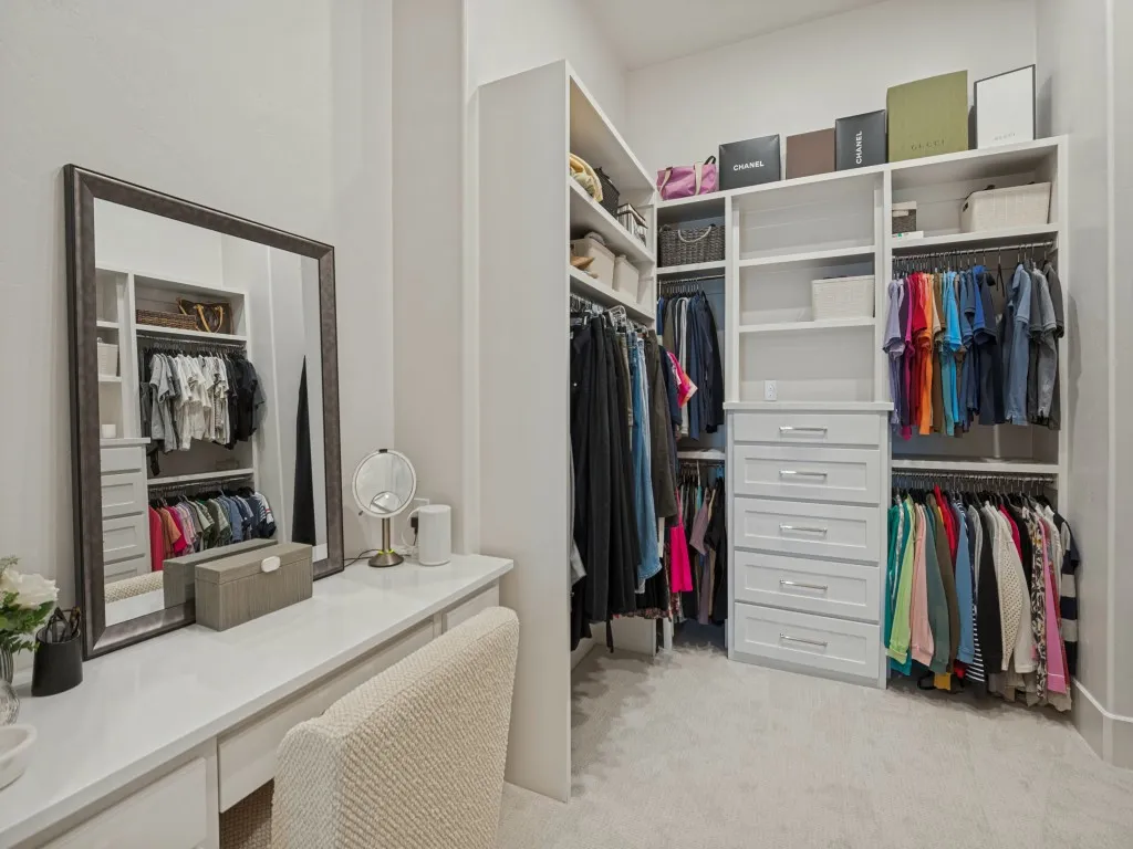 The primary closet is a room within itself. A lovely make-up vanity and lots of room with shelving and drawers.