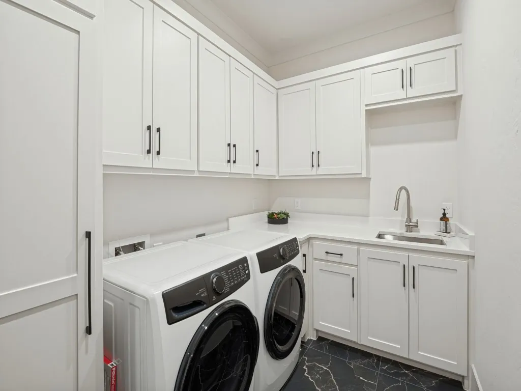 Lots of cabinet space in the laundry room with a sink and utility closet.