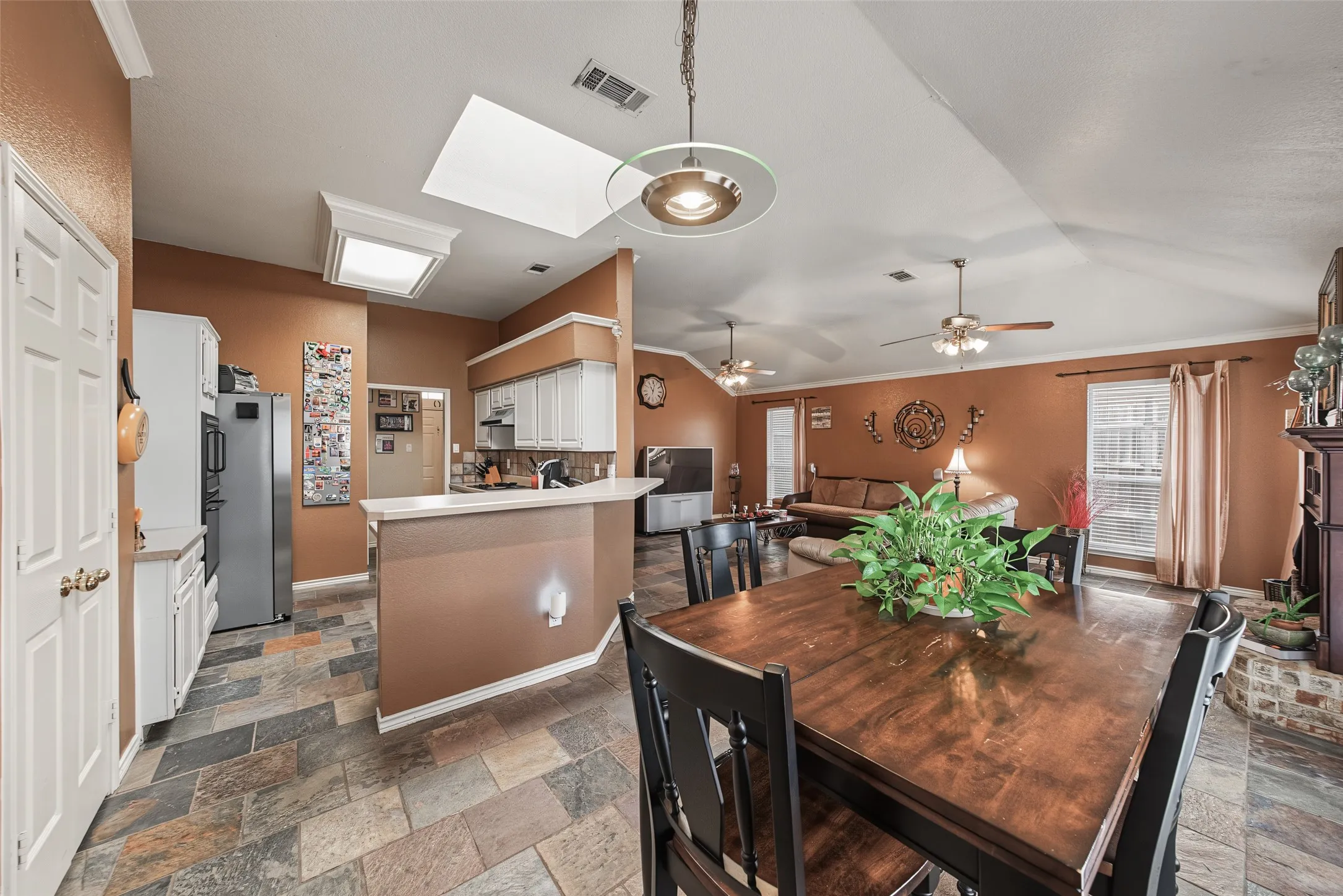 Open-concept living space featuring a vaulted ceiling and tile flooring