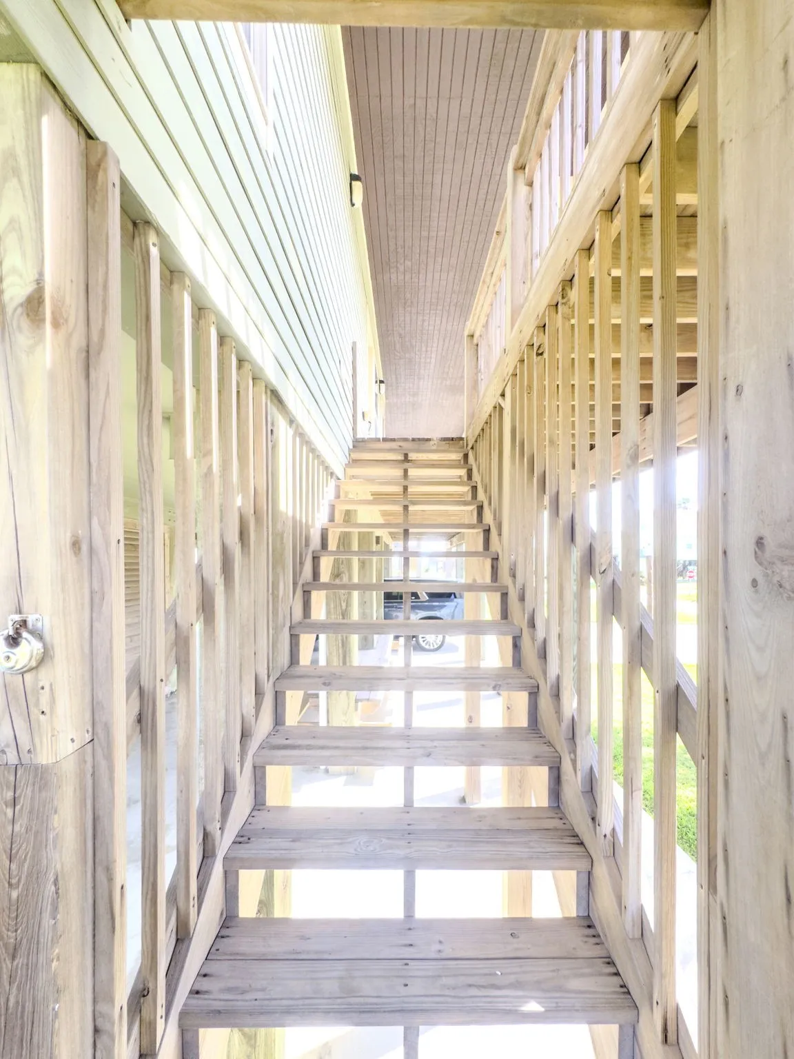 Wood-plank exterior staircase with wood railings and balusters