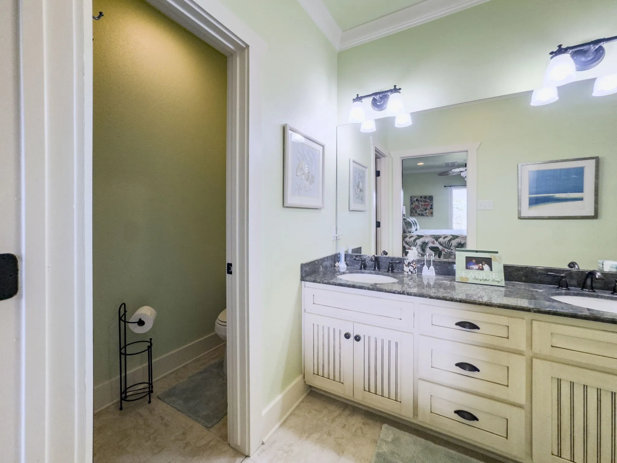 Double vanity featuring dual sinks, dark stone countertops, and integrated storage cabinetry