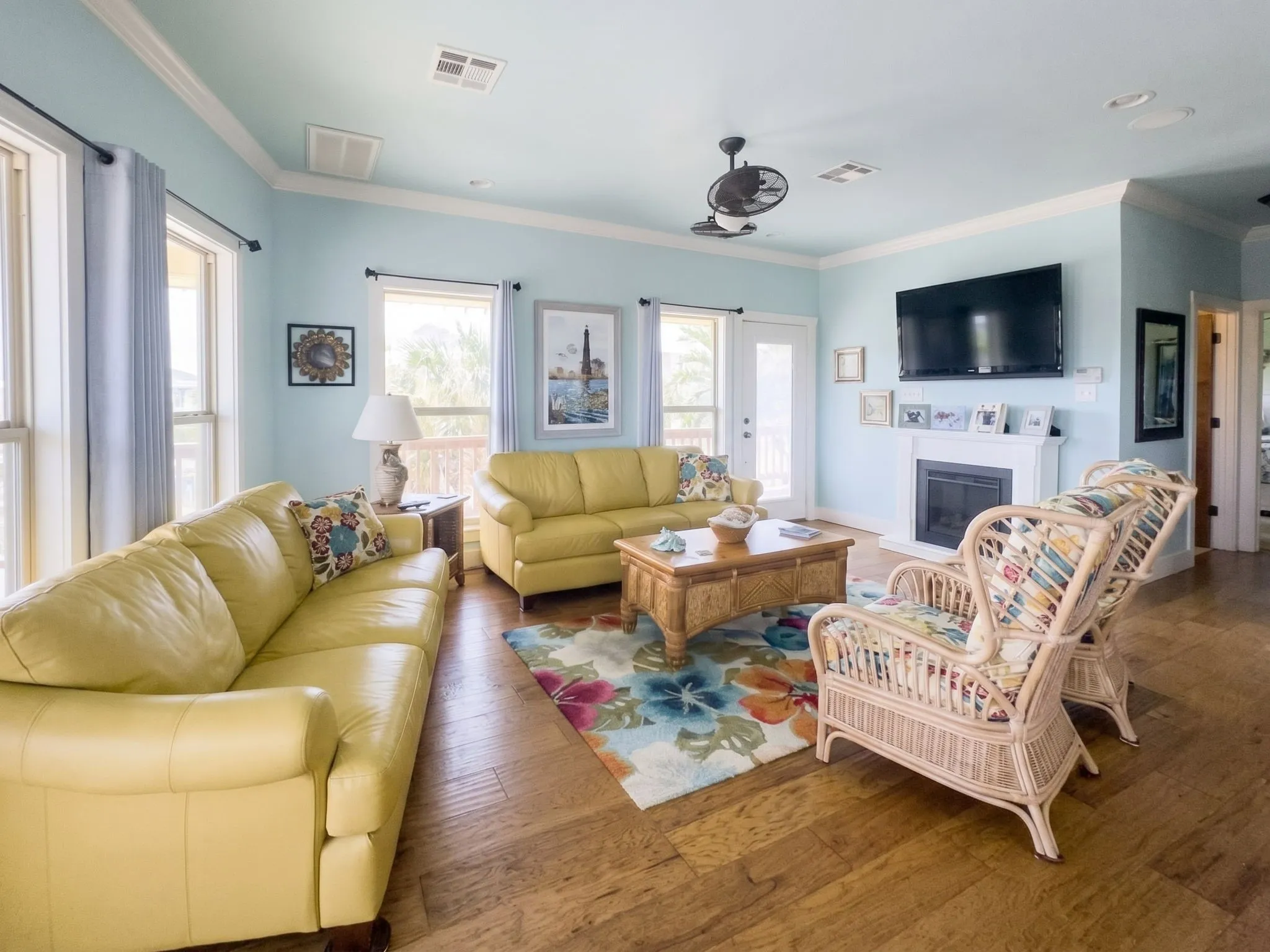 Hardwood-style flooring throughout, featuring a white mantle with an integrated fireplace and transom windows