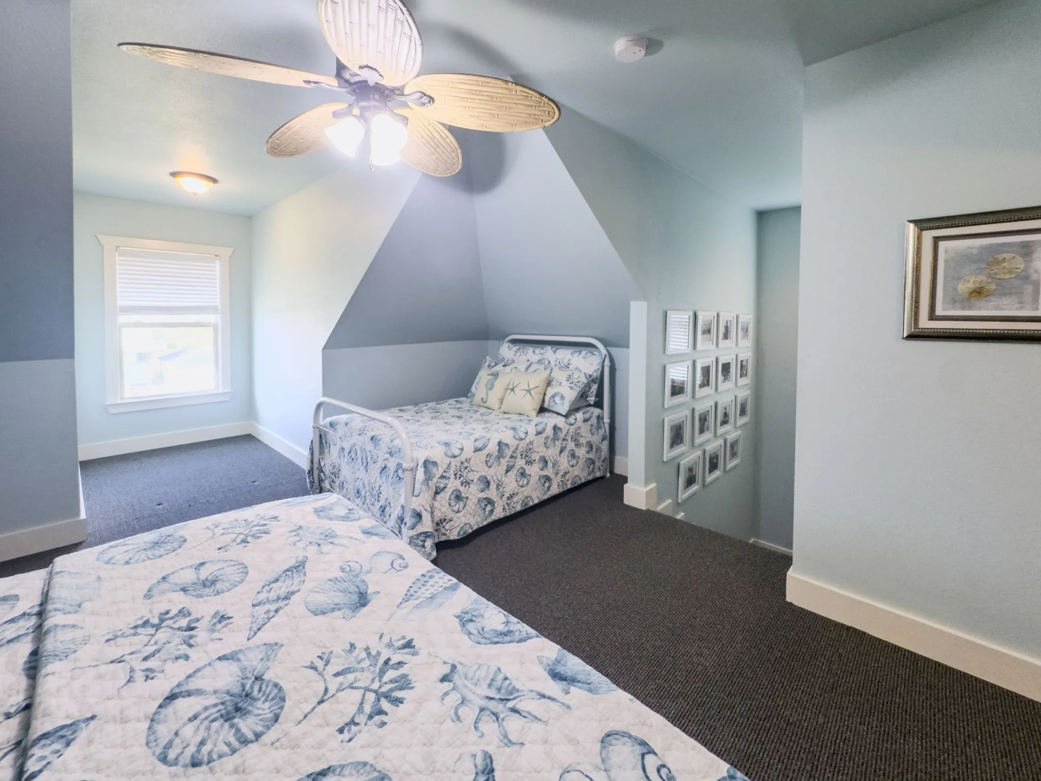 Sloped ceiling room featuring a ceiling fan with integrated lighting, recessed lighting, and a window with blinds
