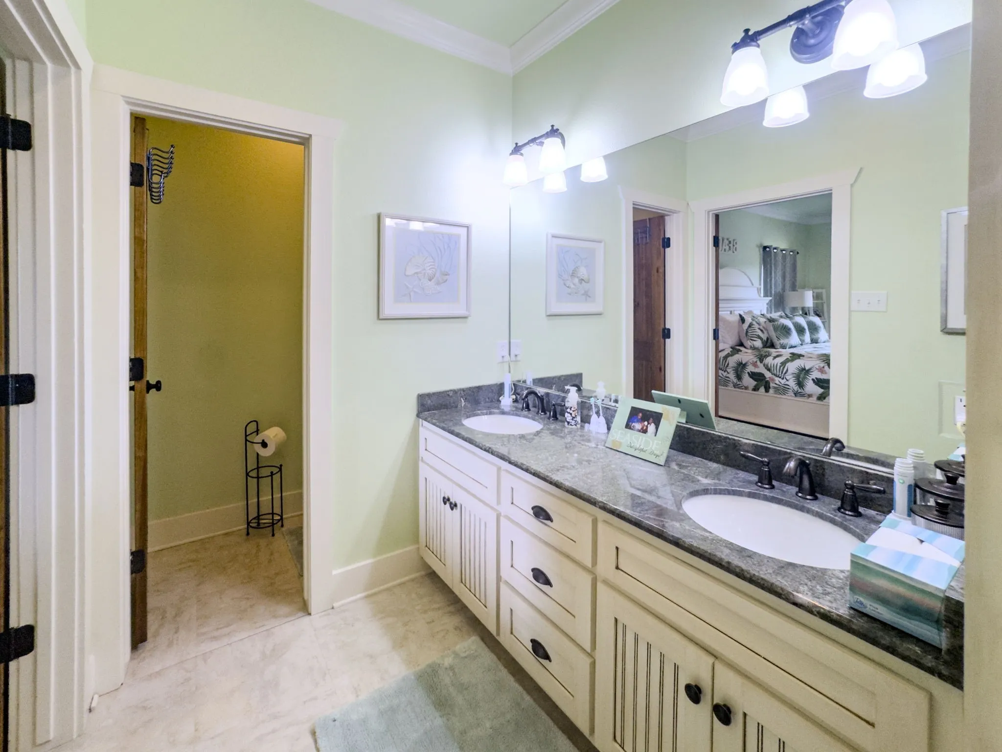 Dual vanity with undermount sinks, stone countertop, white shaker-style cabinetry, and oil-rubbed bronze fixtures