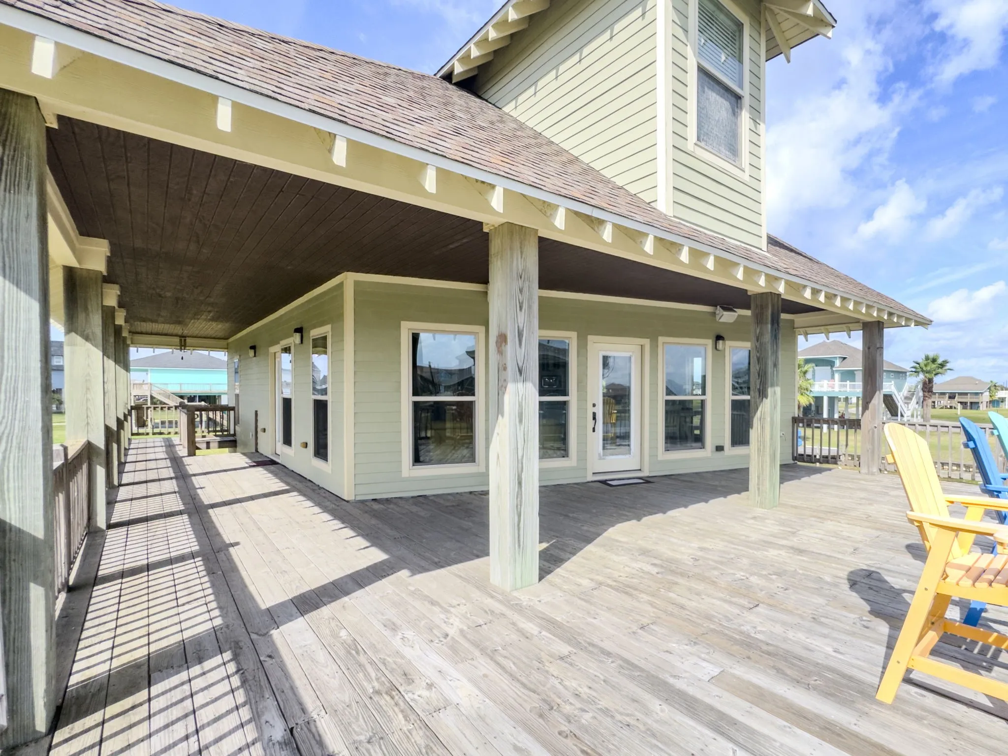 Expansive covered deck with wood flooring and exposed support beams