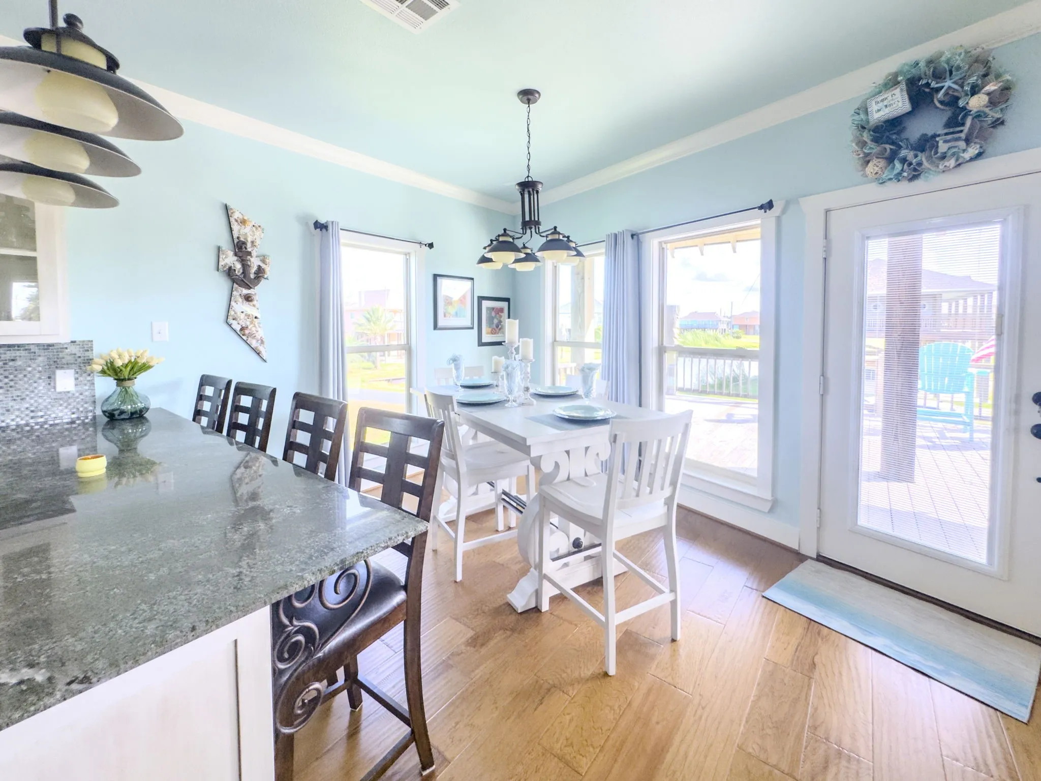 Spacious dining area with wood-finish flooring, multiple windows, and a glass-paneled door