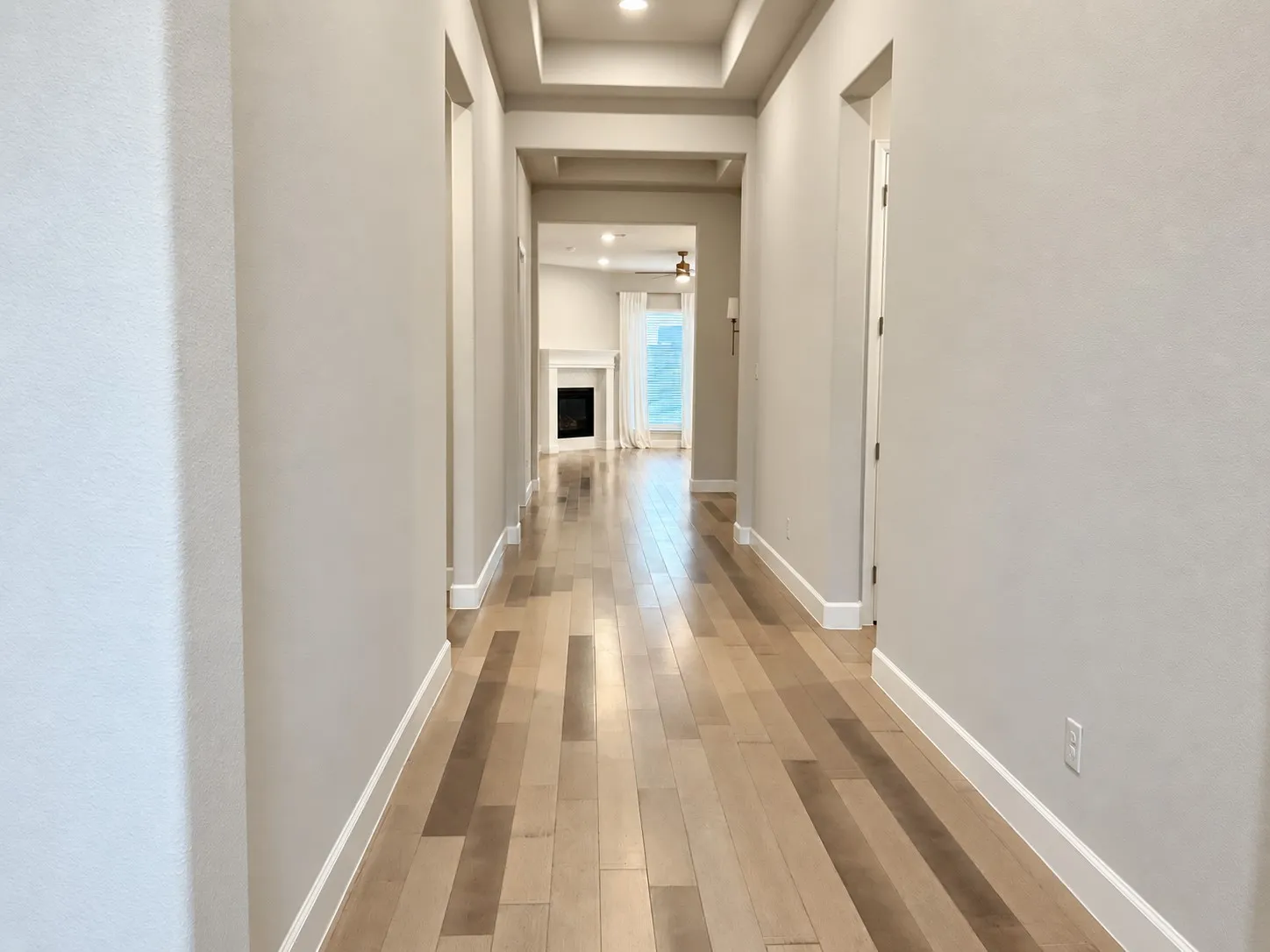 Hallway featuring wood-finish flooring, light-toned walls, and recessed lighting