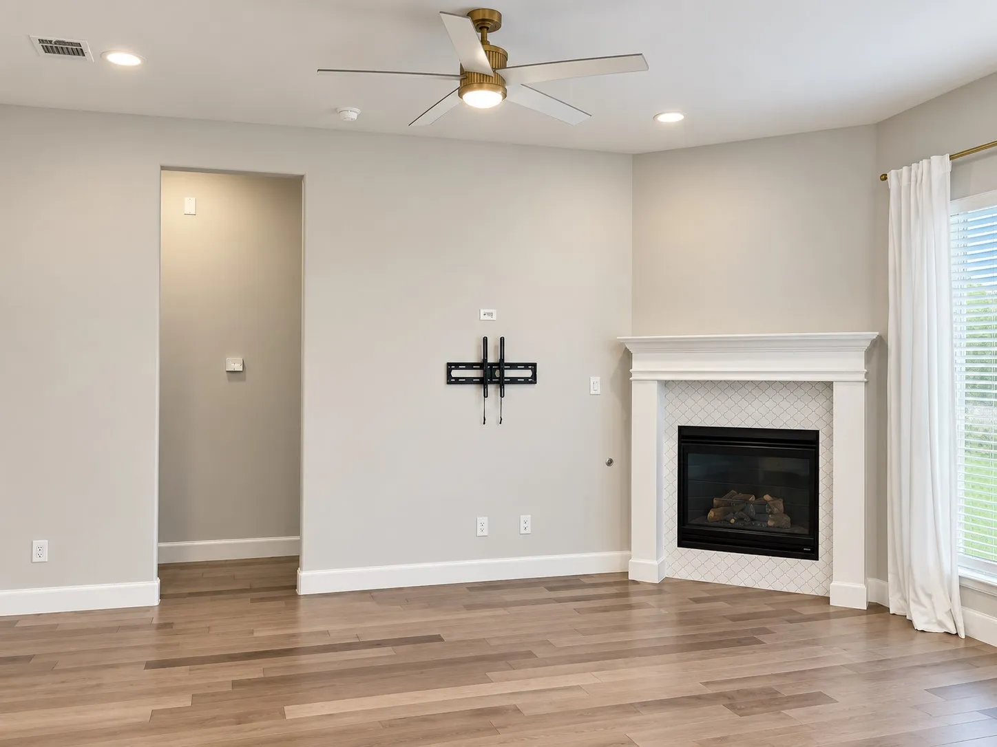 Fireplace with a white mantel and patterned tile surround