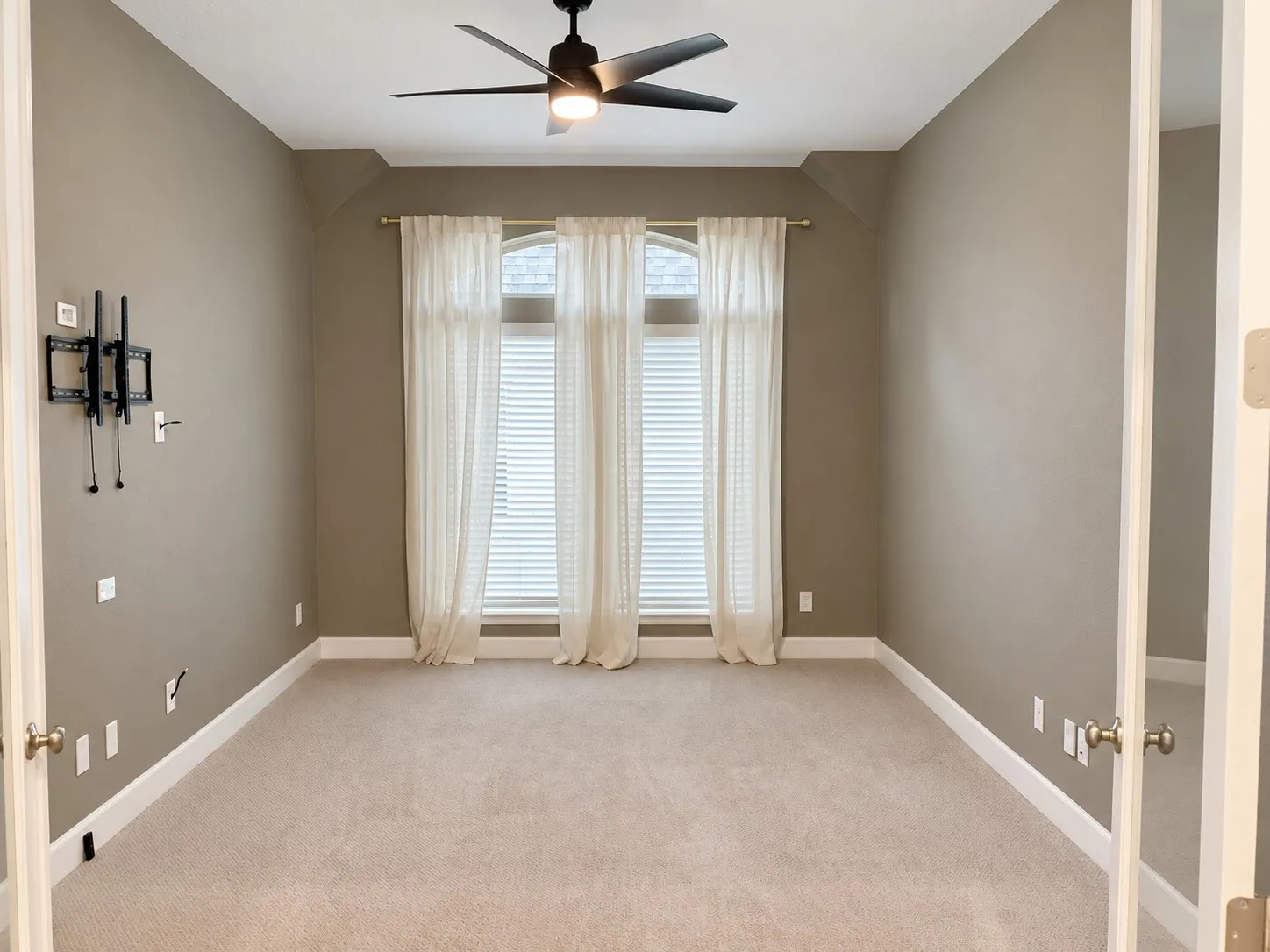 Media Room neutral carpet flooring and glass panel doors