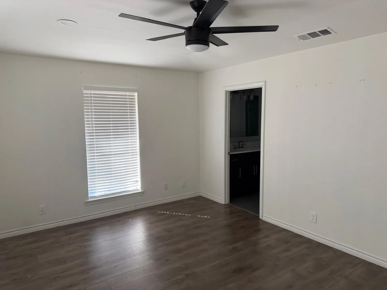 Room with wood-finish flooring, a window with blinds, and a modern ceiling fan