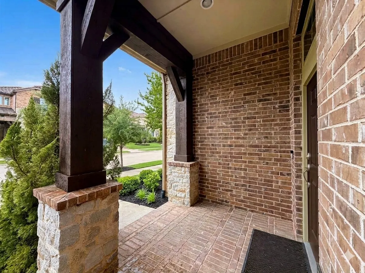 Brick exterior with stone accents and a wood-beamed porch