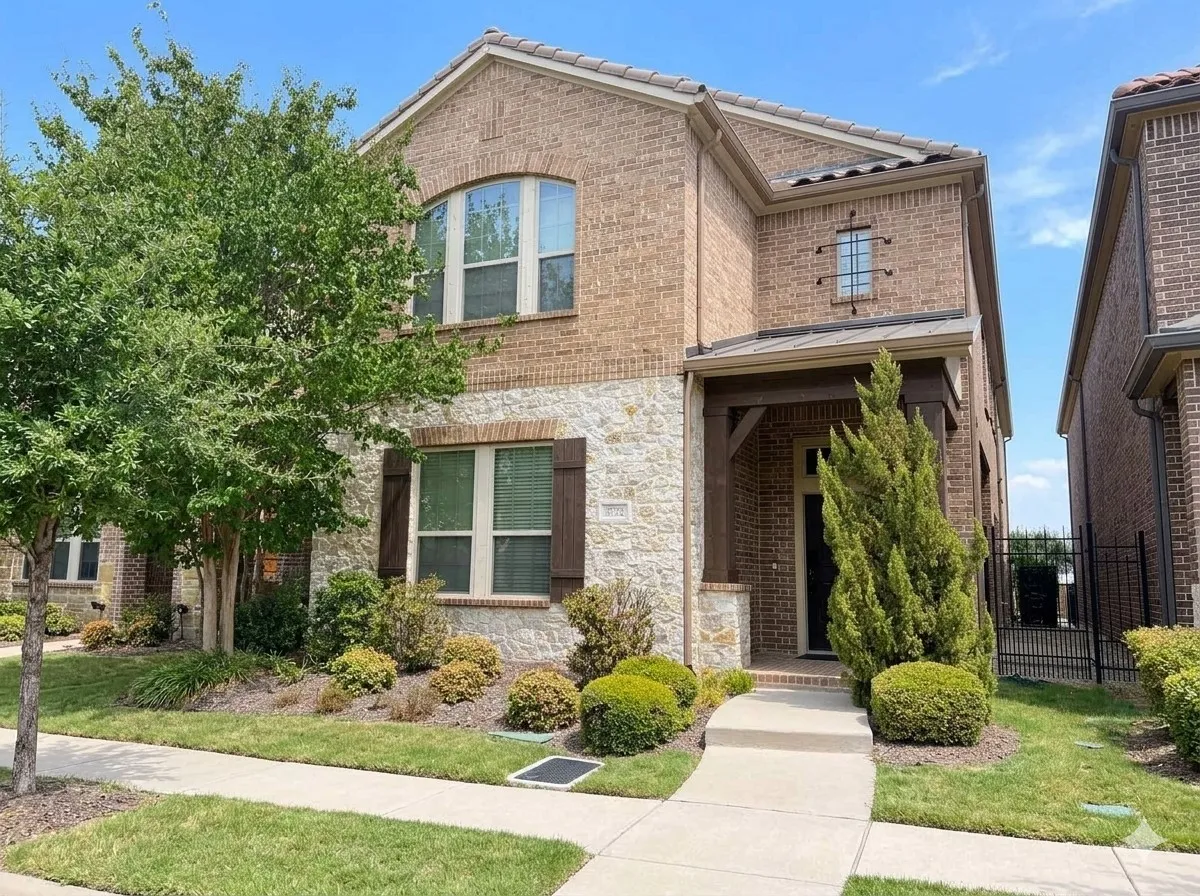Brick and stone facade with wood accents, front porch entry, tiled roof, and established landscaping
