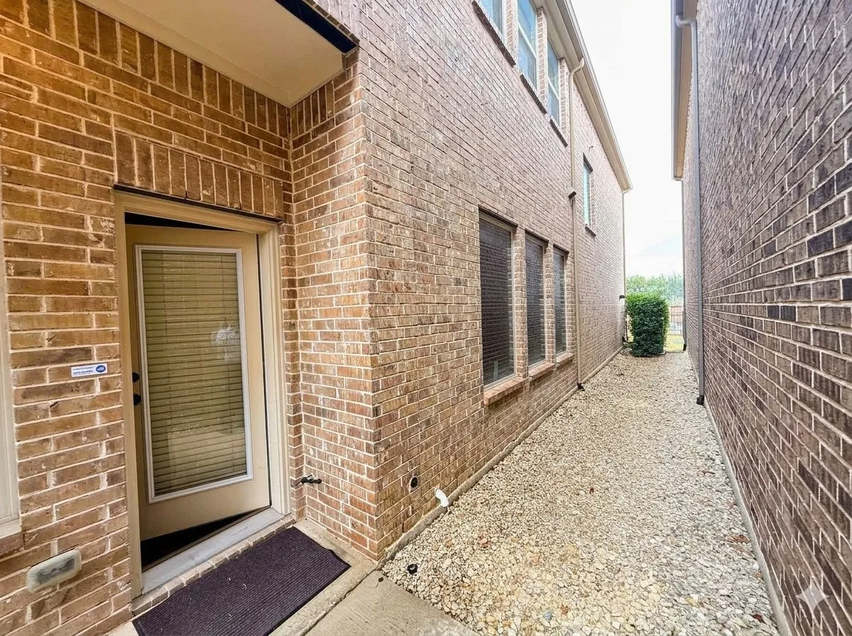 Brick exterior with multiple windows and a glass-paneled door