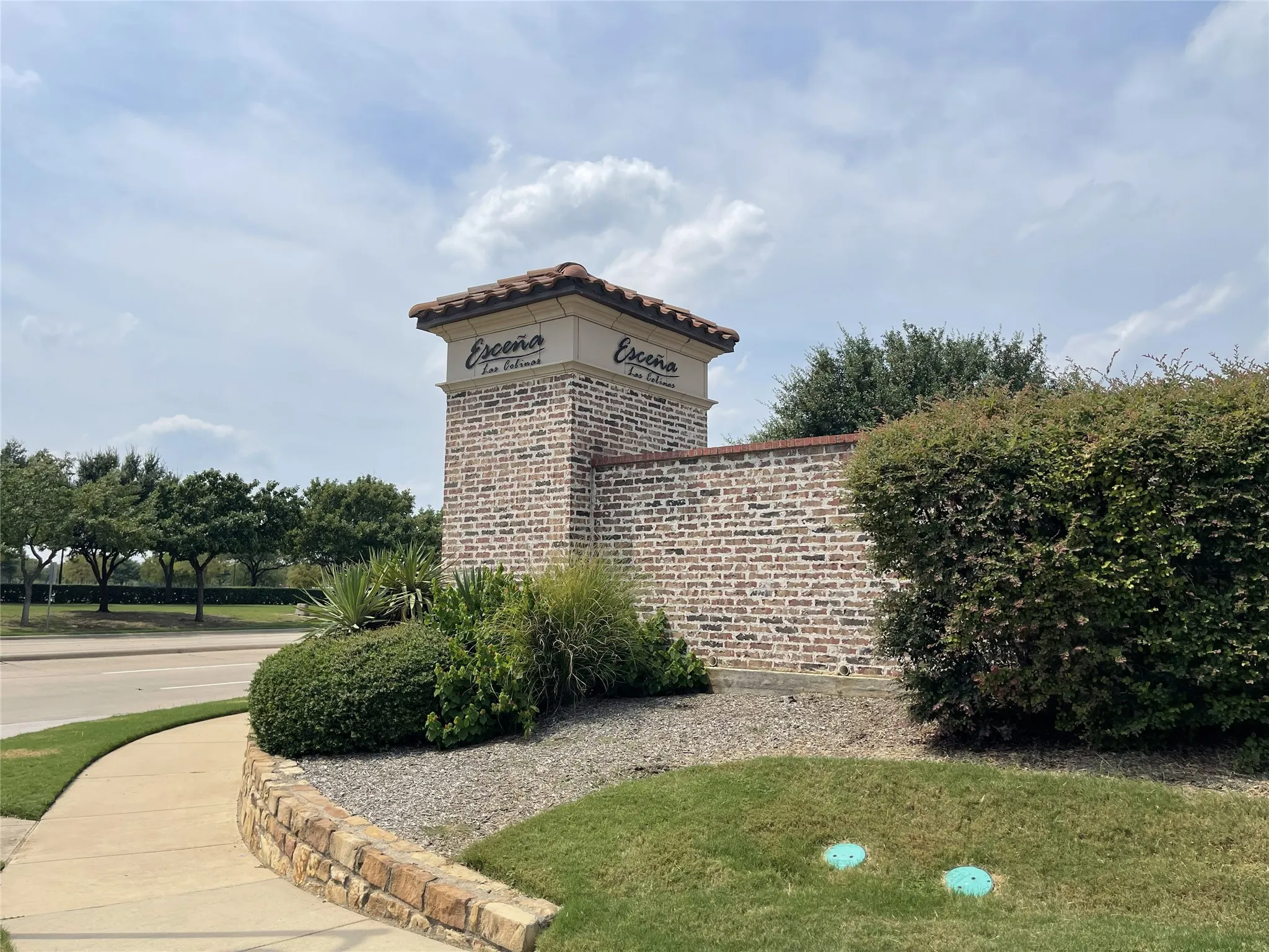 Entry monument featuring a brick pilaster with a tiled cap