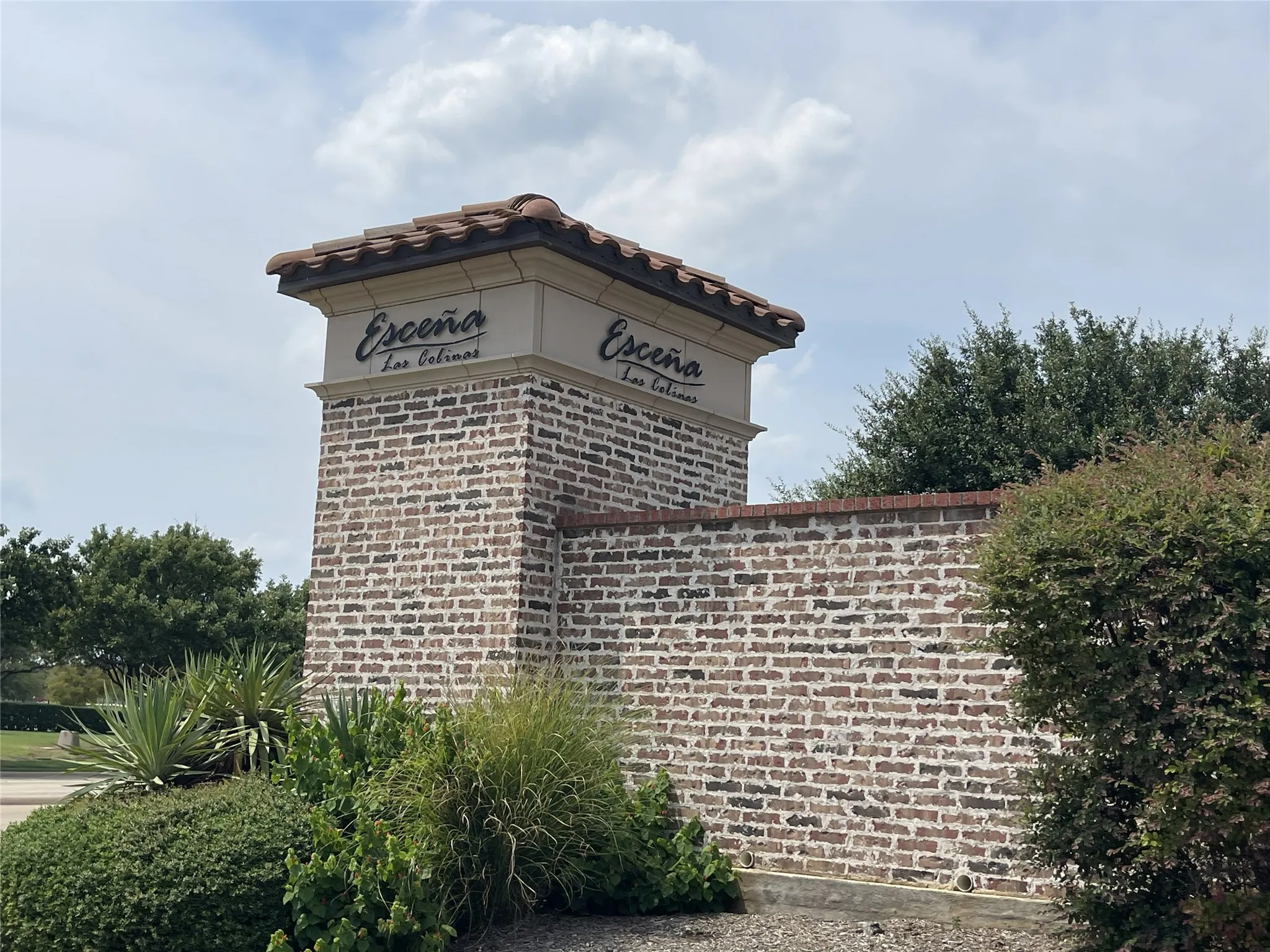 Brick perimeter wall with a stone cap and integrated signage
