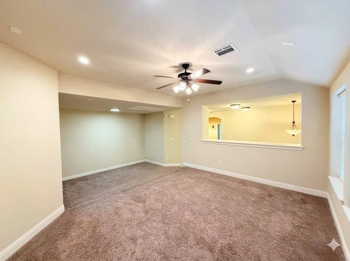 Vaulted ceiling with a ceiling fan, recessed lighting, carpet flooring, and a pass-through opening to an additional room