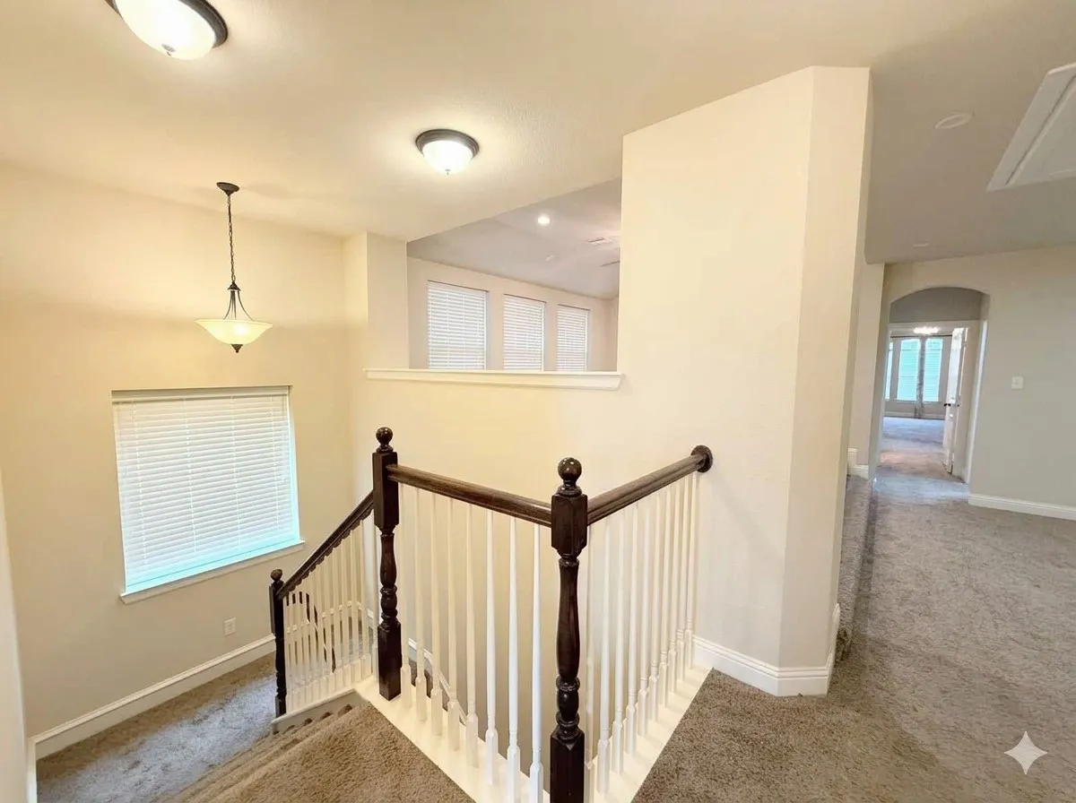 Carpeted staircase with dark wood handrails and white balusters