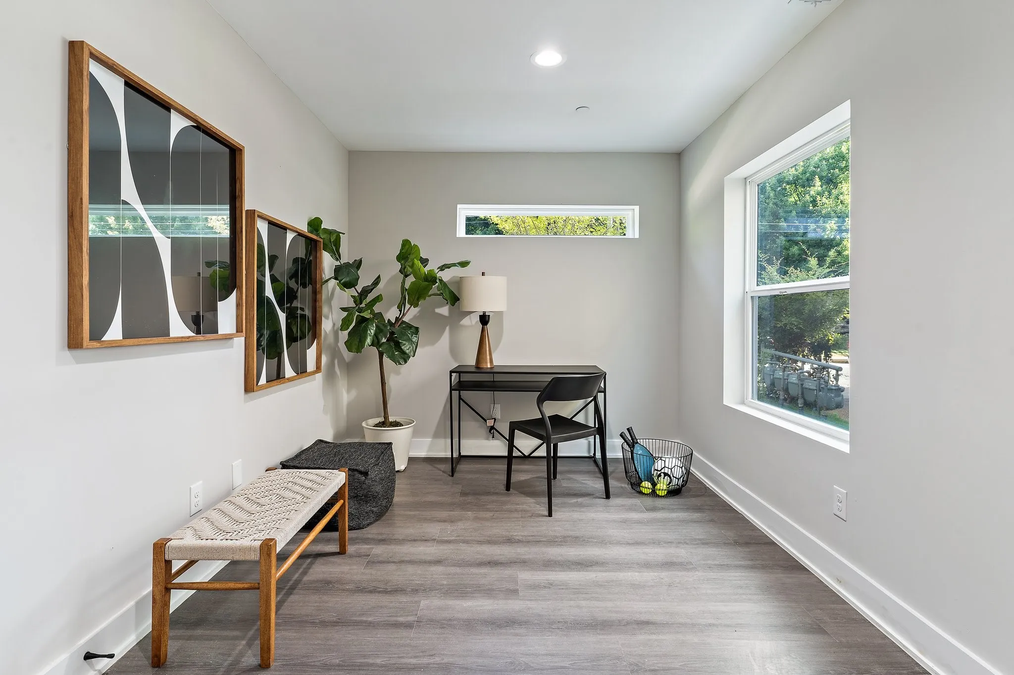 Wood-finish flooring with white trim, recessed ceiling lighting, and multiple windows including a transom window