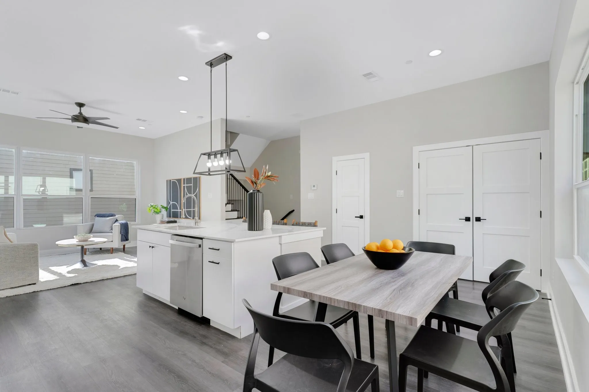 Open-concept living area featuring wood-finish flooring, recessed lighting, and large windows