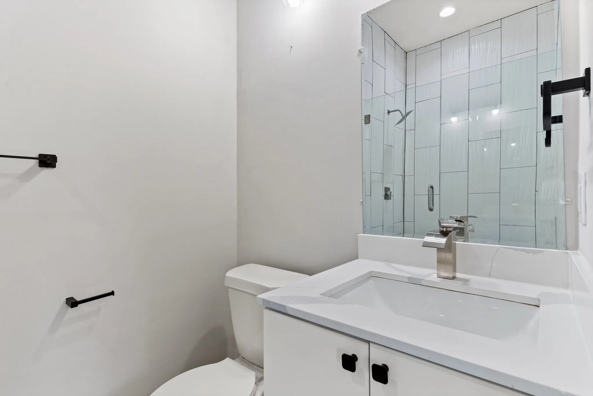Bathroom vanity with an integrated sink, polished chrome faucet, and quartz countertop