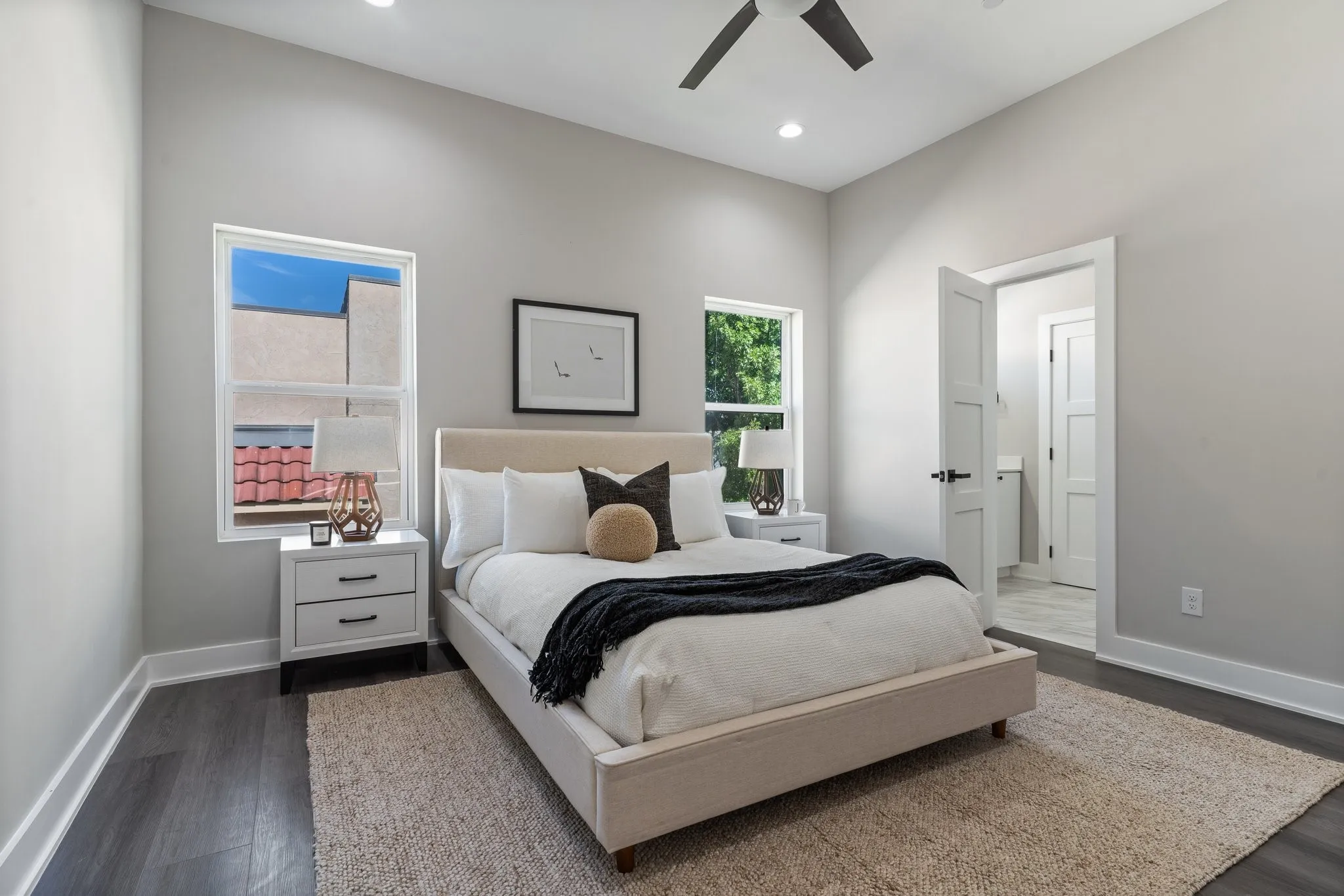 Vaulted ceilings with recessed lighting, dark wood-finish flooring, and white trim throughout