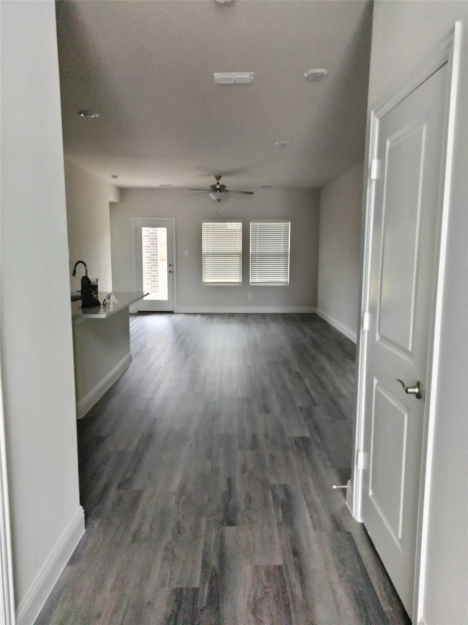 Open-concept living space featuring wood-finish flooring, recessed lighting, and a ceiling fan