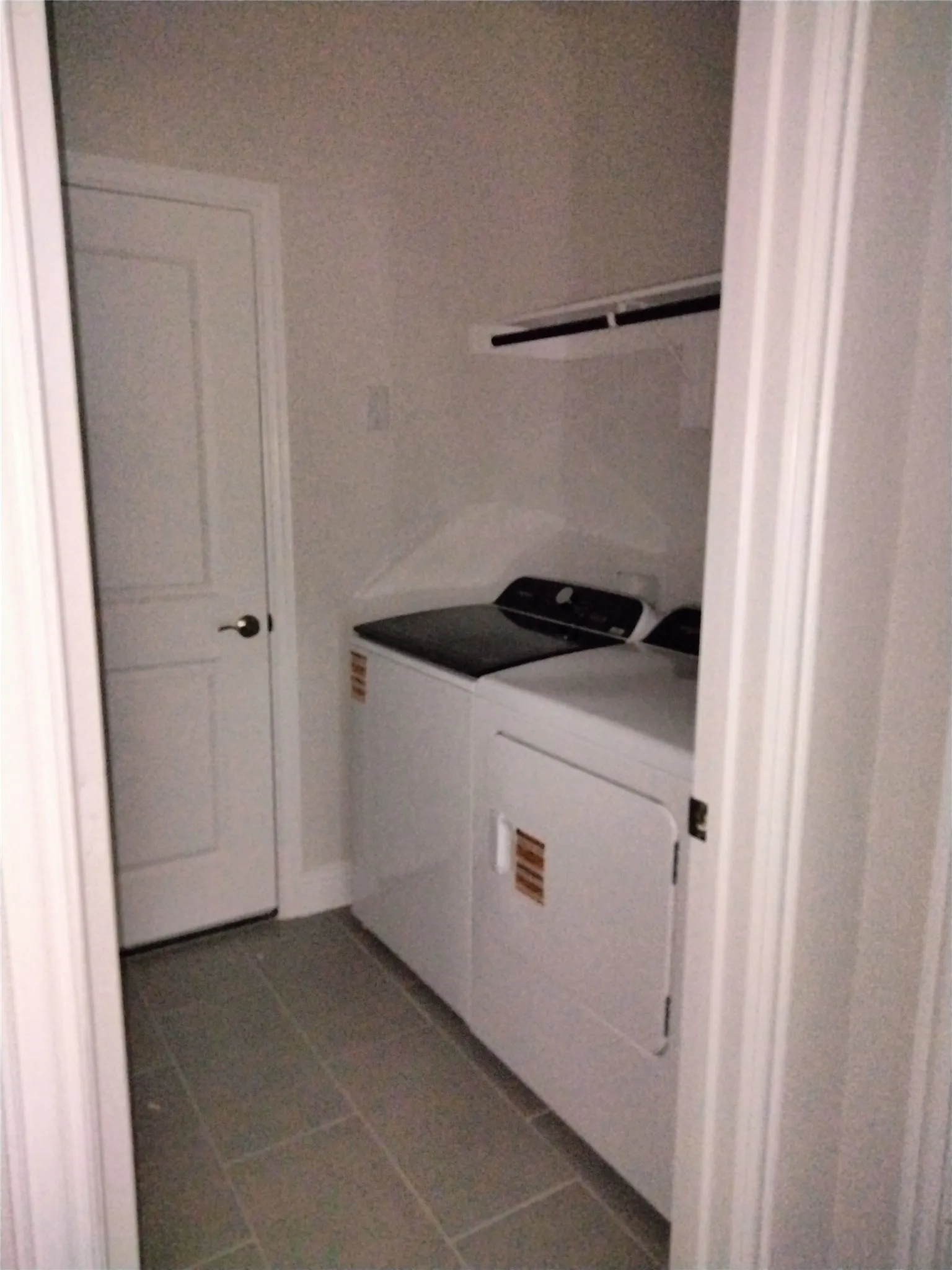 Dedicated laundry area featuring tile flooring and an integrated shelf
