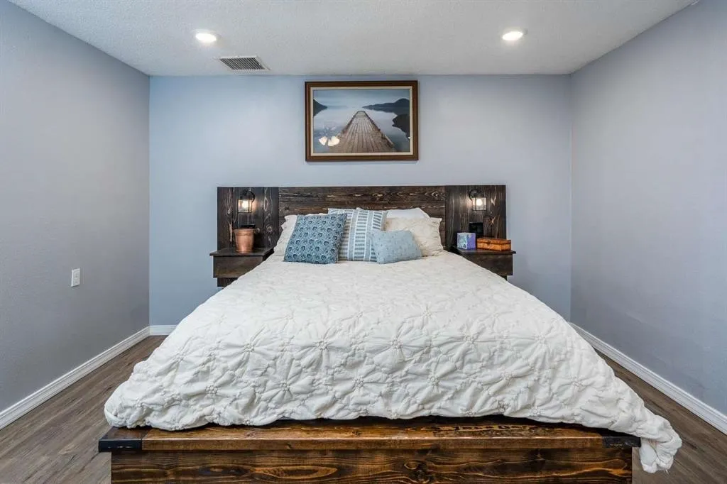 Wood-finish flooring, recessed lighting, and light blue wall color