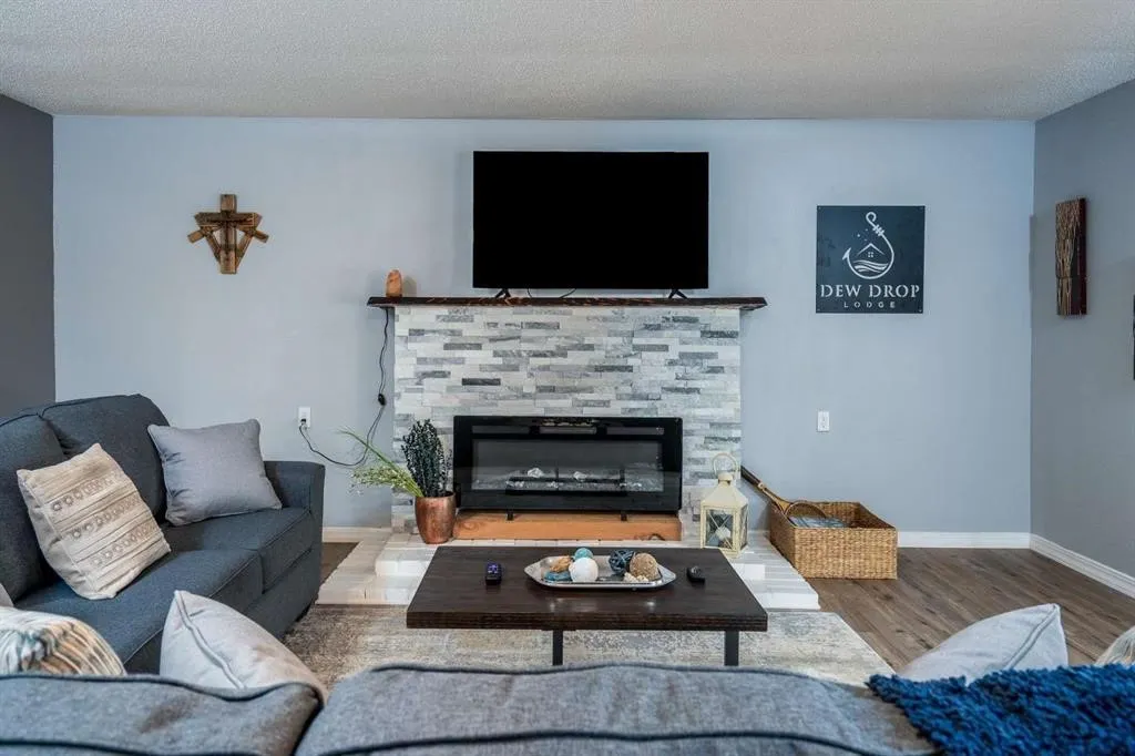 Fireplace featuring stacked stone surround, wood-finish mantel, and built-in electric insert