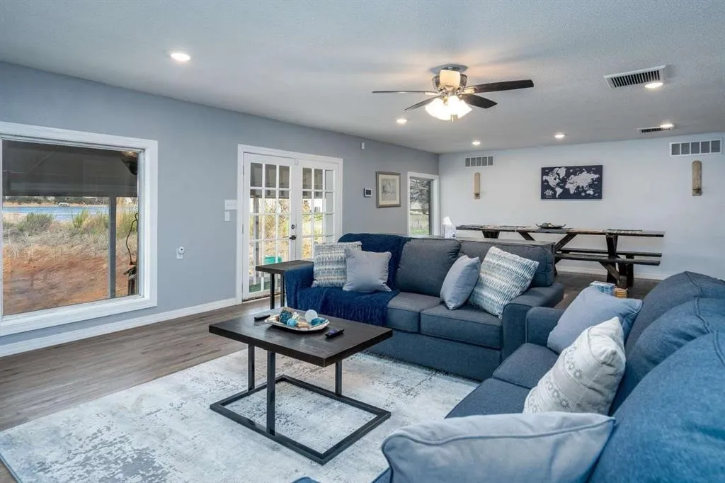 Spacious living area featuring wood-finish flooring, recessed lighting, and a ceiling fan