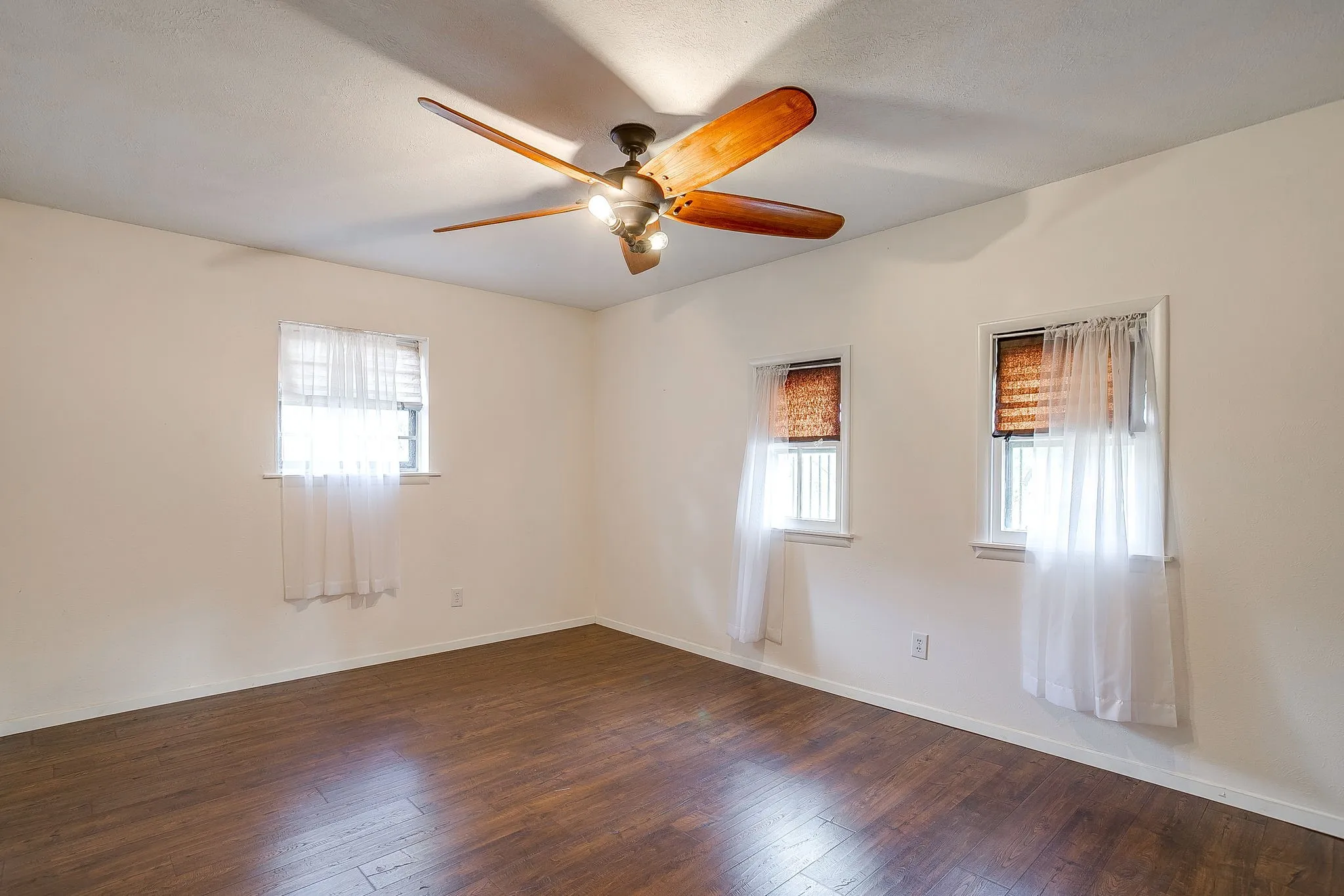 Wood-finish flooring with a ceiling fan light fixture