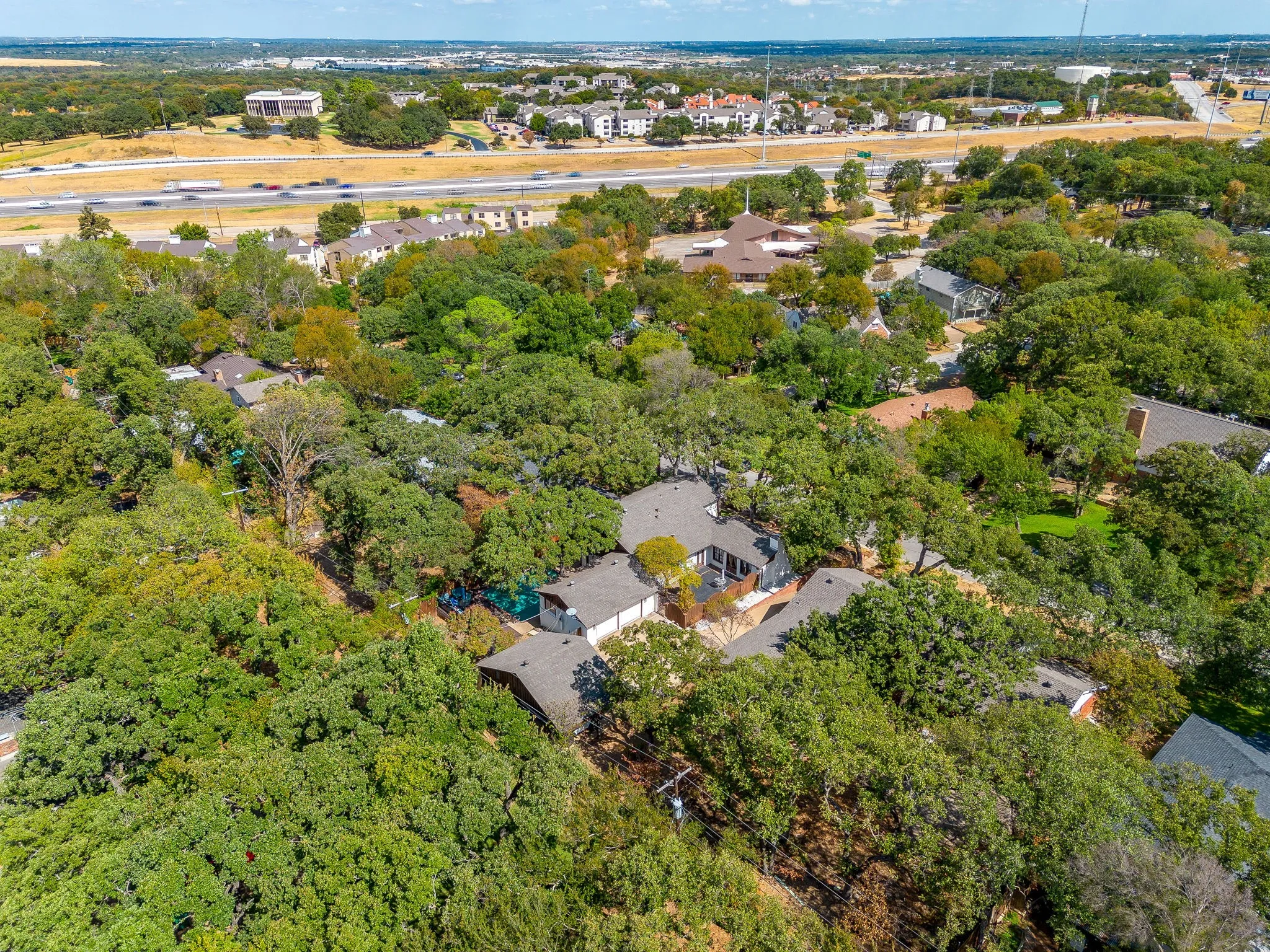 Lush tree canopy surrounds the property, offering extensive natural landscaping